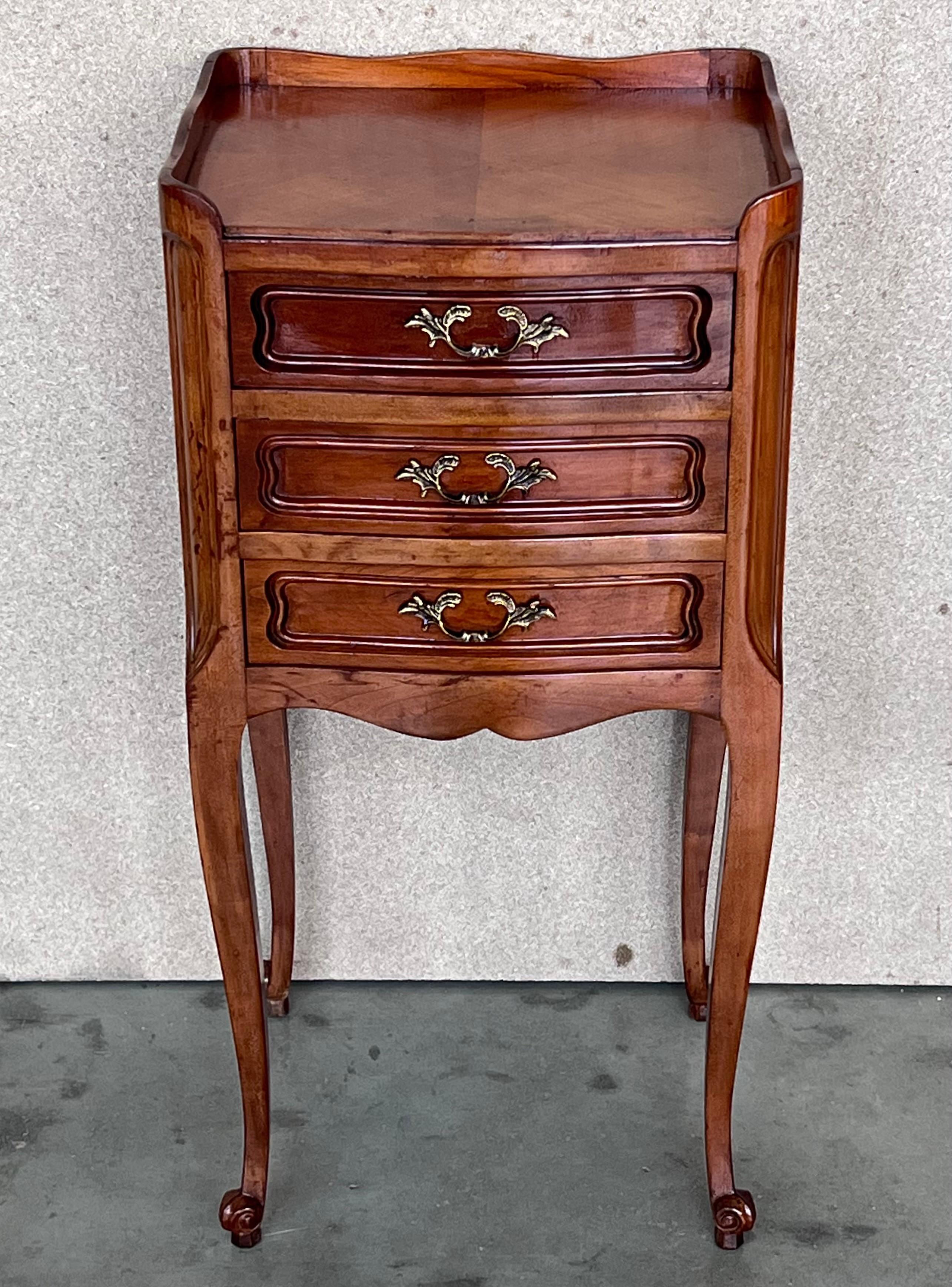 A pair of Antique French Louis XV Marquetry top nightstands. Subtle contours and scroll shapes are evident in the corner posts and legs, which support serpentine sides and an arched front façade for a curvaceous effect. The tops are luxurious