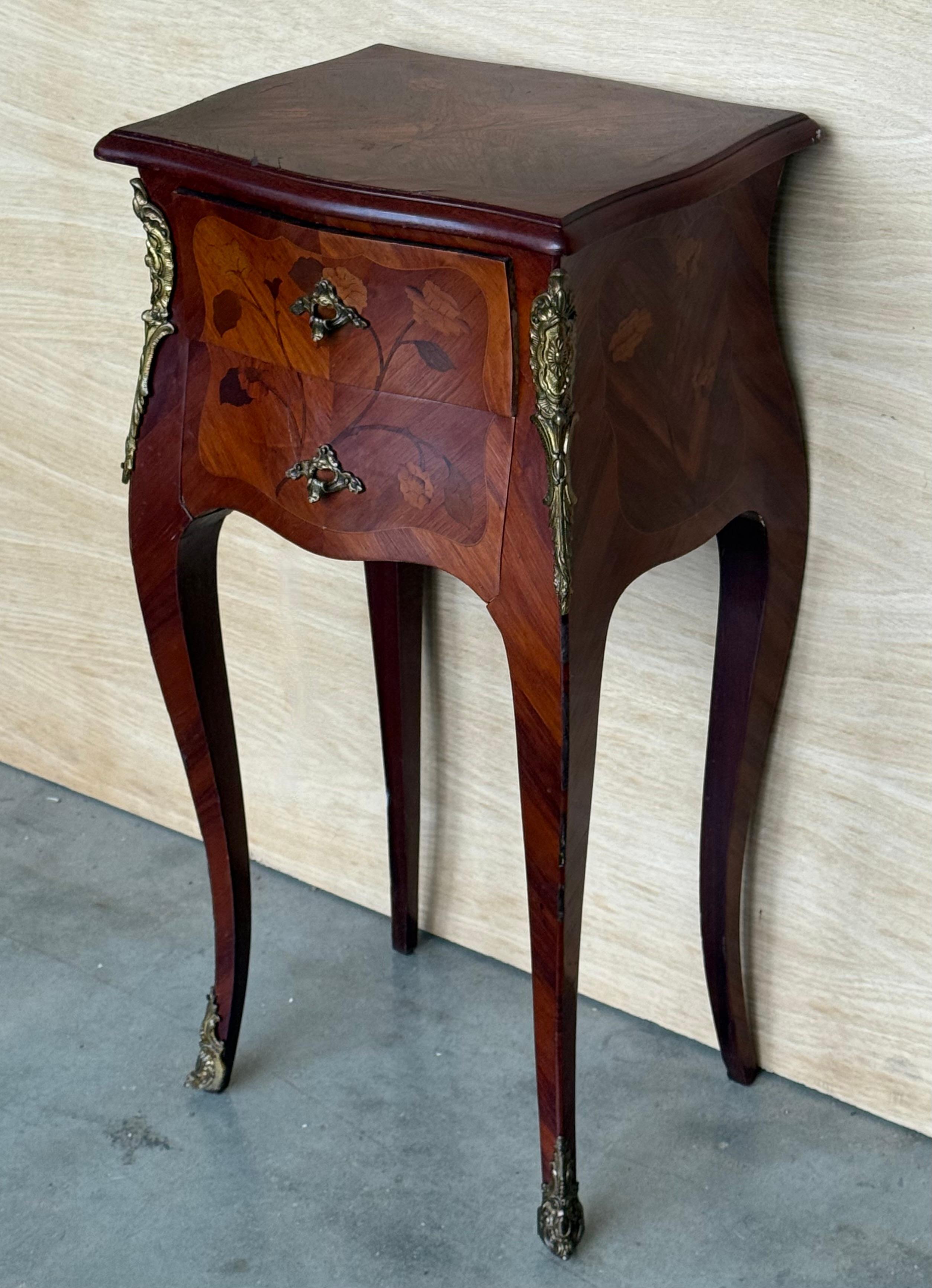 A pair of Antique French Louis XV Marquetry marble top nightstands. Subtle contours and scroll shapes are evident in the corner posts and legs, which support serpentine sides and an arched front façade for a curvaceous effect. The tops are luxurious