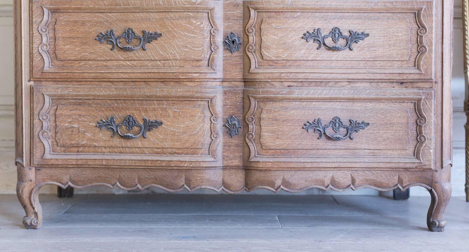 Stately antique commode in oak with three drawers. This amazing piece is in incredible condition and is very solidly built. Lovely, dark hardware decorates the drawers and large keyholes sit in the indented center of each drawer. Very minimal stains