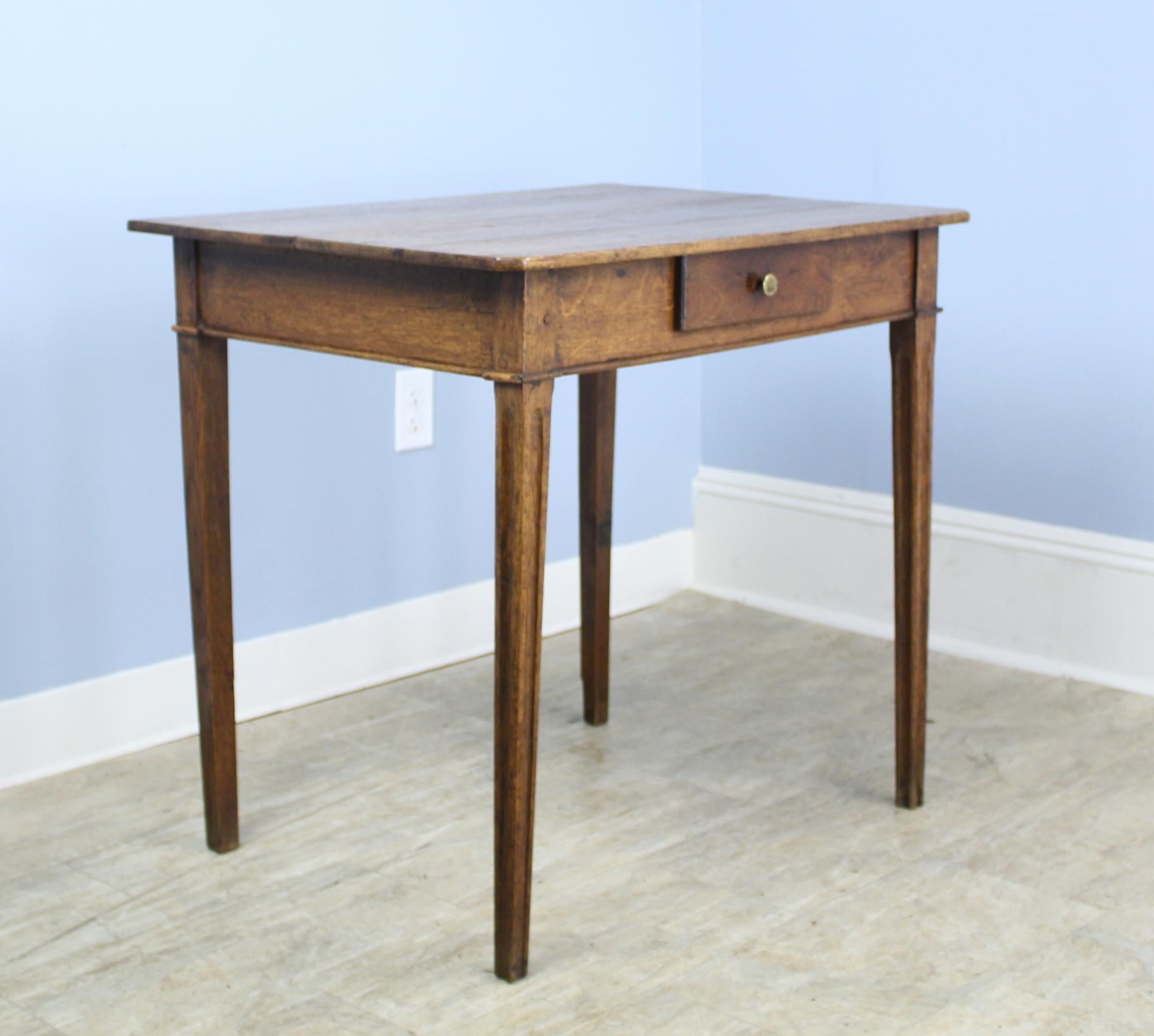 A handsome oak side table with canted corners, reeded legs and fine grain. Single drawer and carved detail at each corner complete the look. There is a slight warp to the front right leg which does not affect the stability of the table. No wobble.