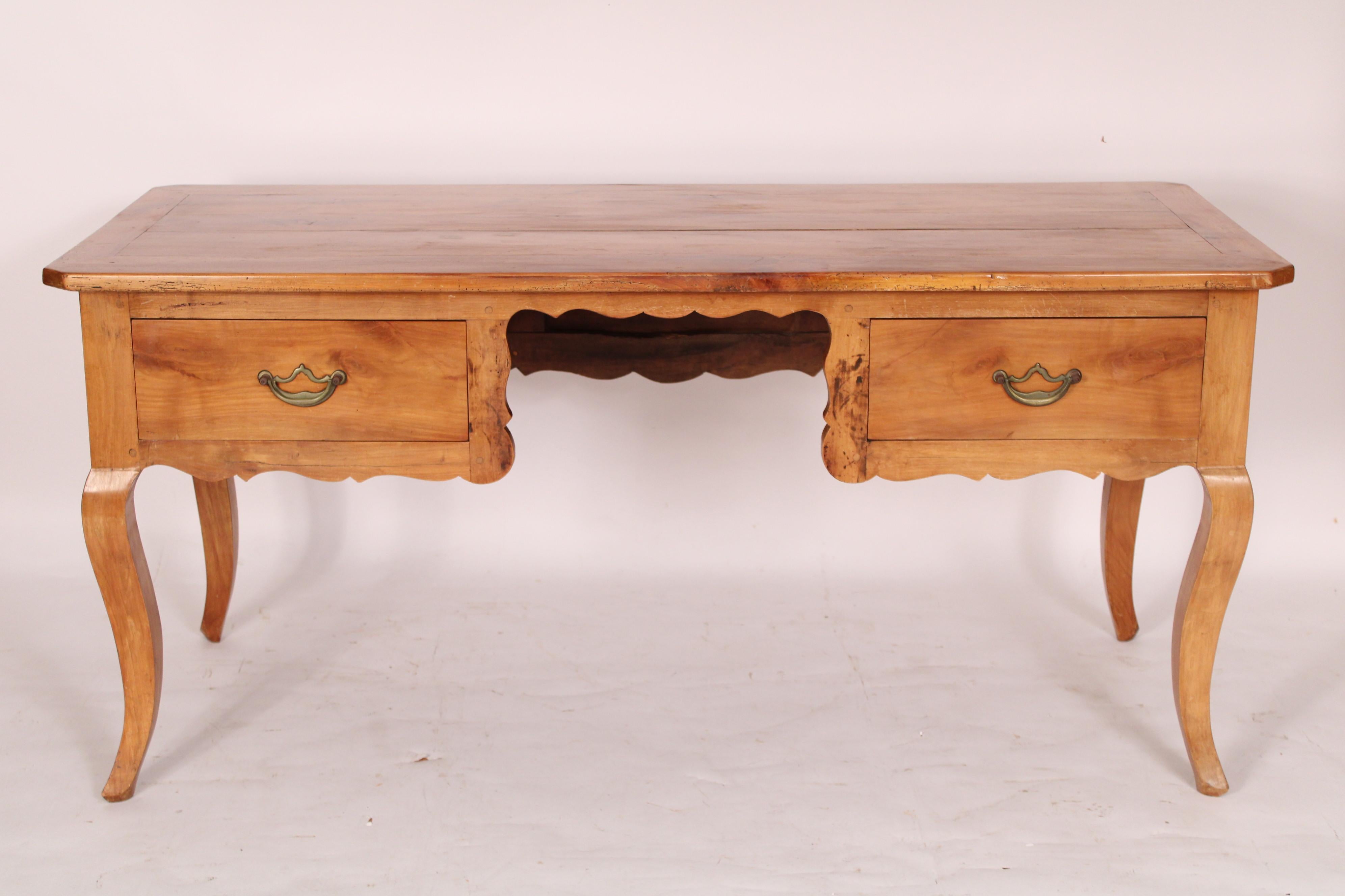 Antique Louis XV style fruit wood writing table / desk, 19th century with alterations. With a rectangular top with slightly beveled edges and canted corners, two frieze drawers with brass hardware, resting on cabriole legs. Mortise, tenon and peg
