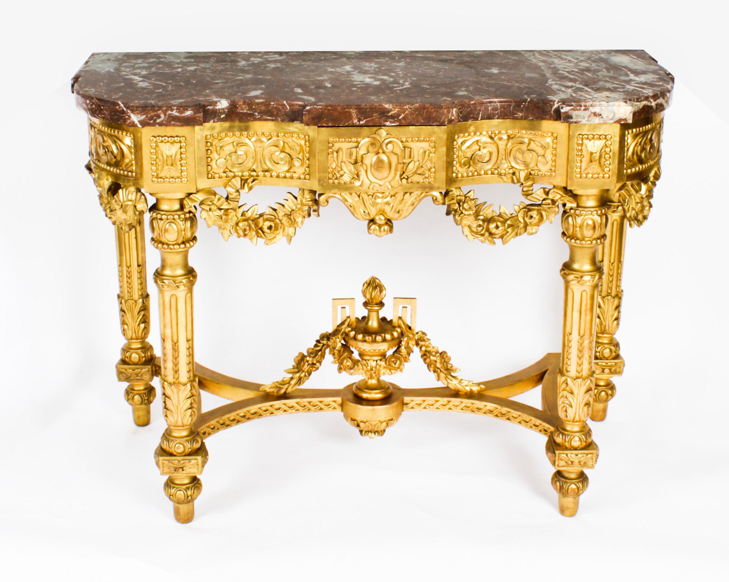 A fine antique Louis XV Revival carved giltwood marble topped console table, circa 1870 in date.
 
This finely carved giltwood console table is surmounted with an exquisite shaped rectangular Rouge de Rance marble top above a frieze carved with