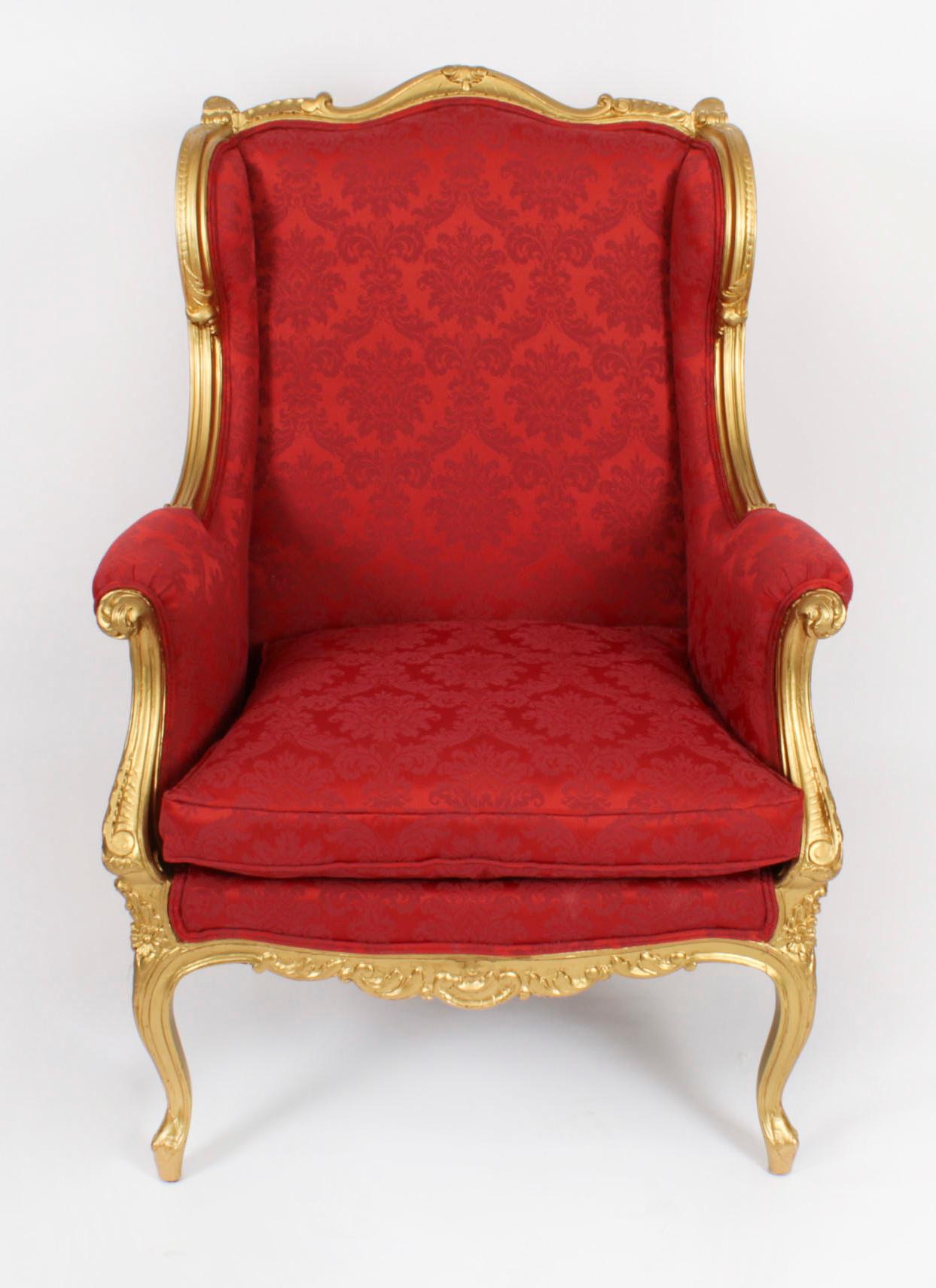 This is a beautiful antique French Louis XV revival carved giltwood tub shaped Bergère, dating from circa 1880.

The wingback armchair with hand-sculpted giltwood frame that envelopes the plush claret damask fabric upholstery all around, with