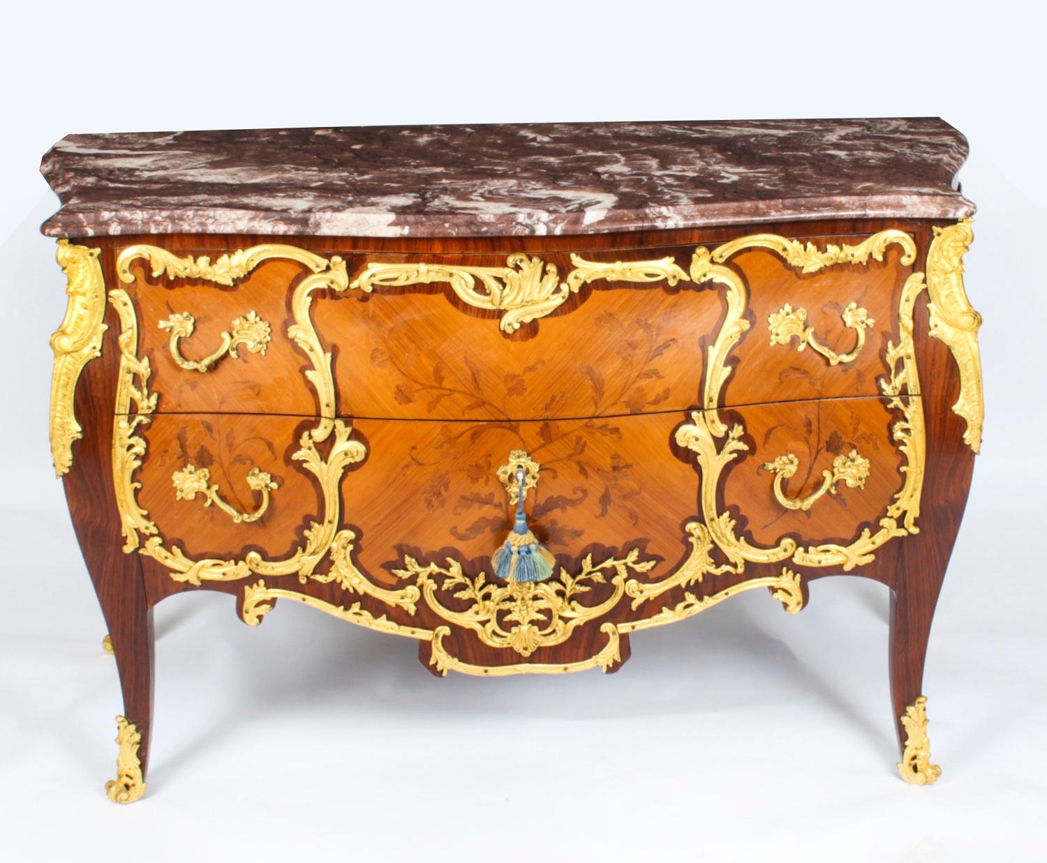 This is a beautiful antique French Louis XV Revival amaranth ormolu mounted commode, in the manner of Leonard Boudin, dating from the early 20th Century.
The two drawer commode with its fabulous rouge veined marble top features elaborate foliate