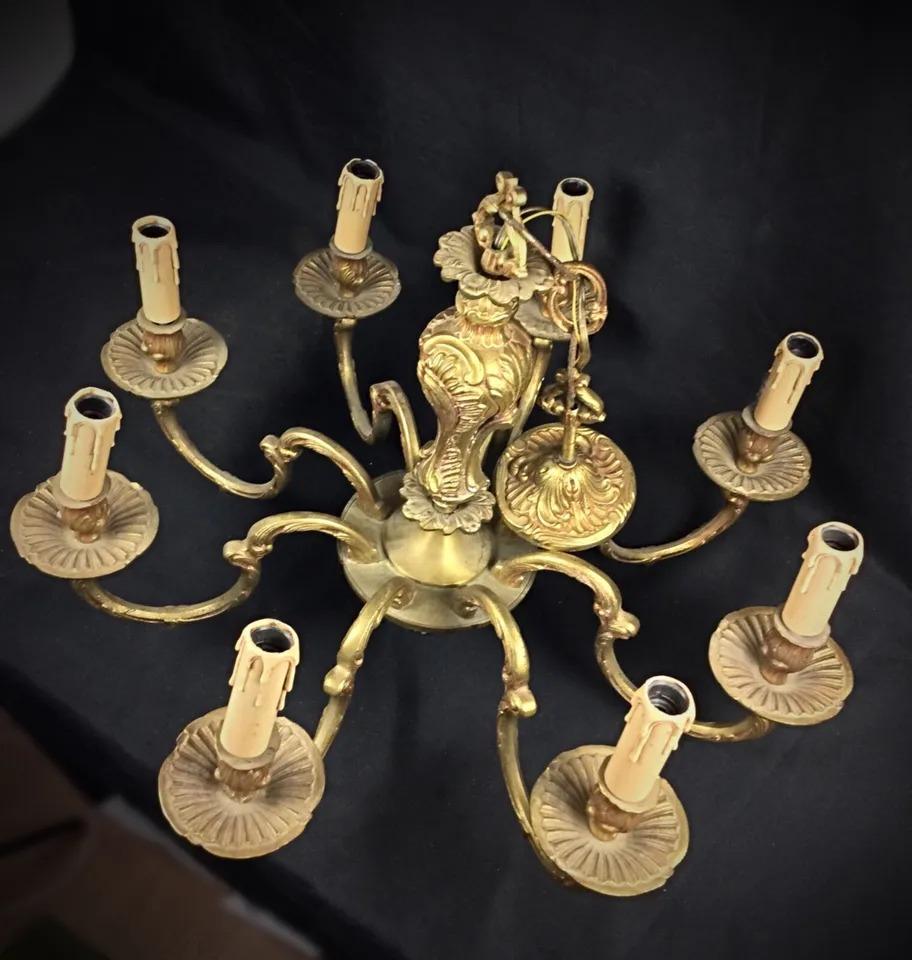 This exquisite antique chandelier in Louis XV style is crafted from solid bronze and features 8 elegant branches. Its intricate design adds a luxurious touch to any interior space. Though the chandelier is in very good condition, it could benefit