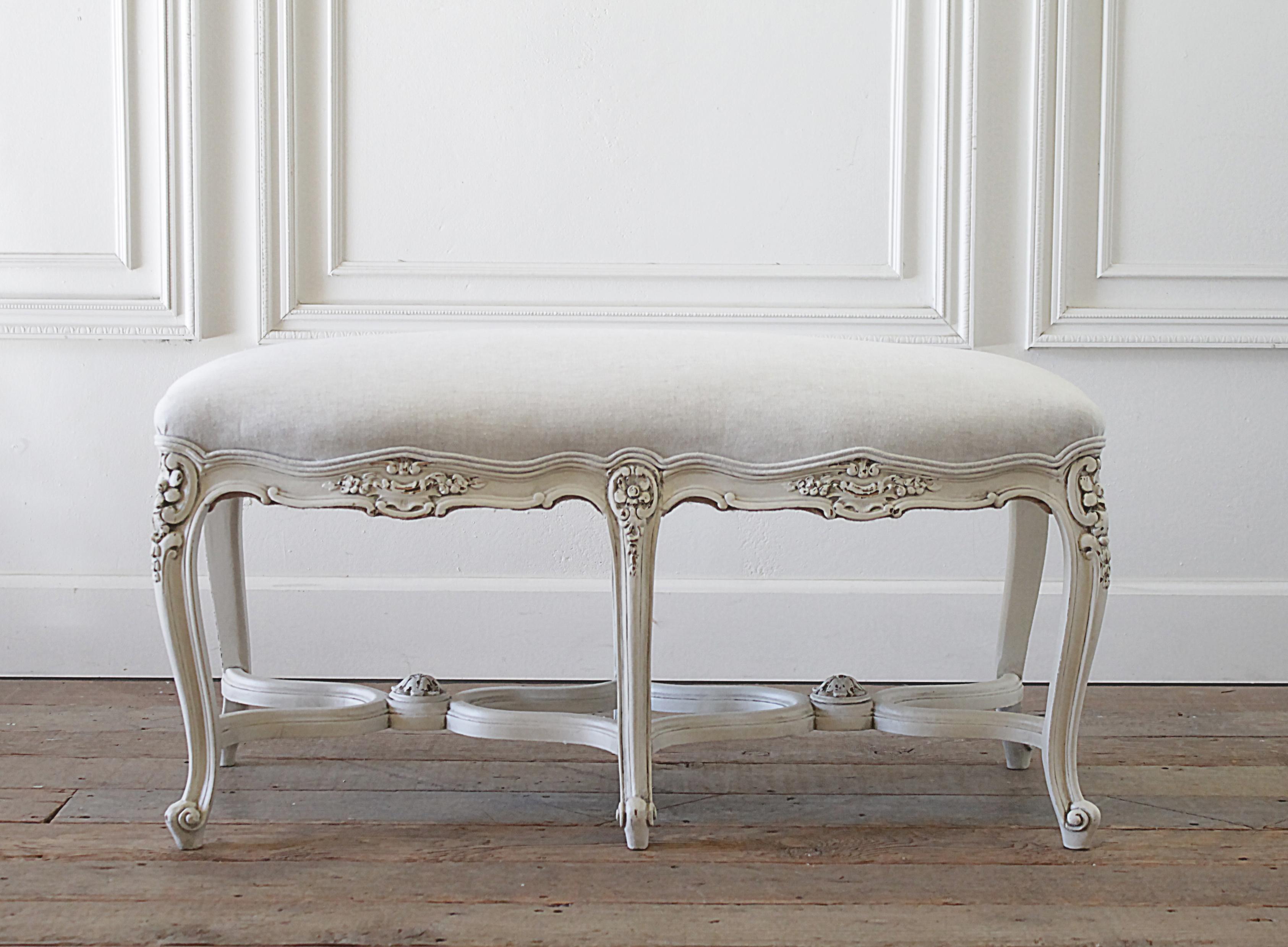 Antique Louis XV style bench with natural linen upholstery. We painted this bench in a soft white color with subtle distressed edges, and finished the upholstery with a 100% pure Belgian linen in a light natural greige color. Very solid and sturdy