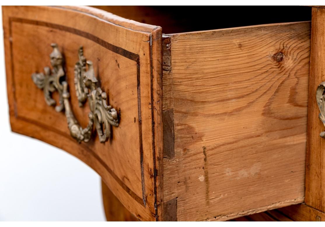 Commode ancienne de style Louis XV avec montures en bronze. La commode à bandes croisées présente des coins à onglet, une façade en serpentin, des panneaux latéraux en retrait, des pieds arrière droits et des montures en bronze sur les pieds avant.
