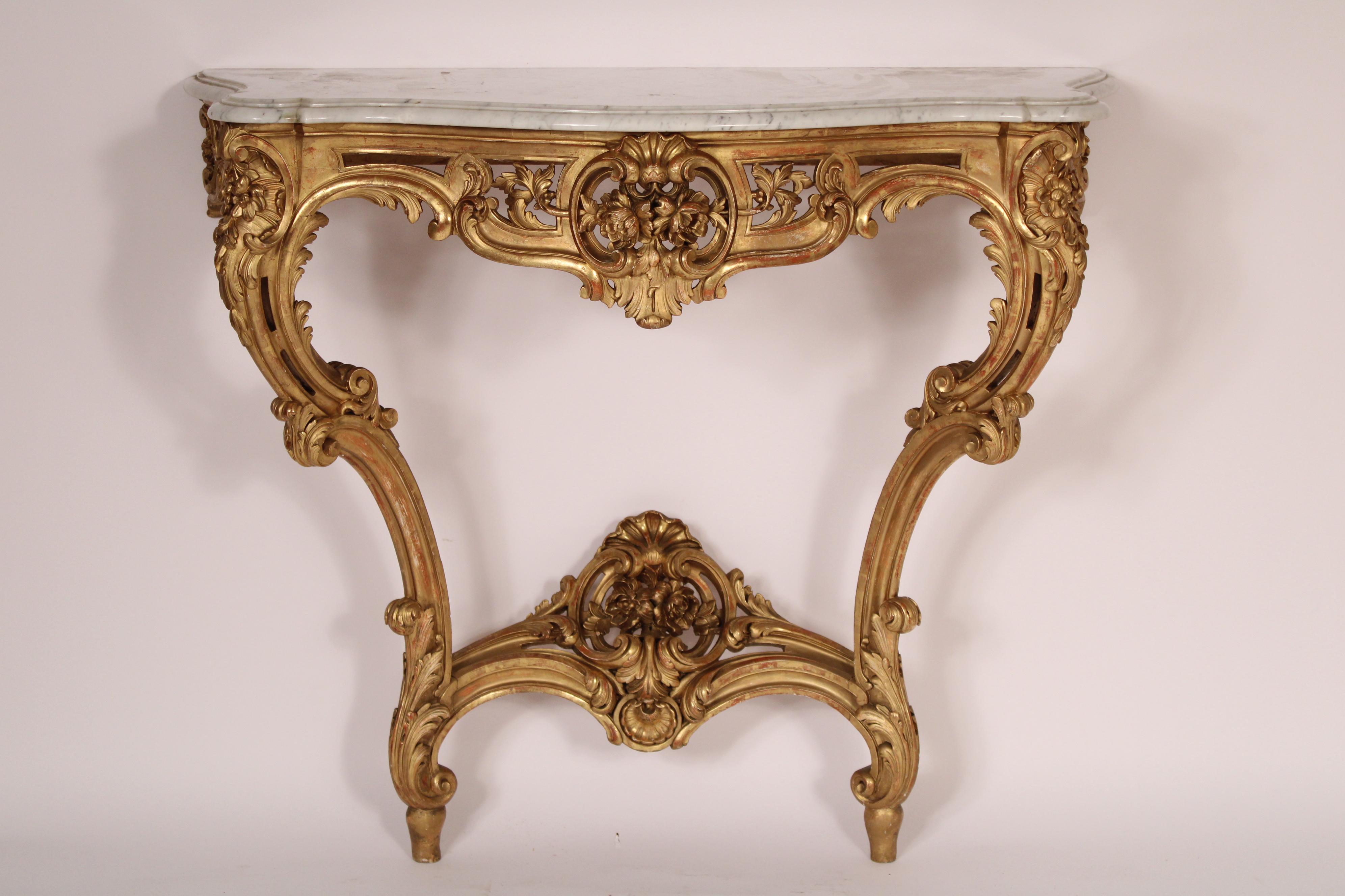 Console ancienne de style Louis XV en bois doré (feuille d'or) avec plateau en marbre, vers 1910. Plateau en marbre de Carrare avec bords avant et latéraux joliment détaillés, frise sculptée de feuillages, pieds cabriole et barre d'appui. 