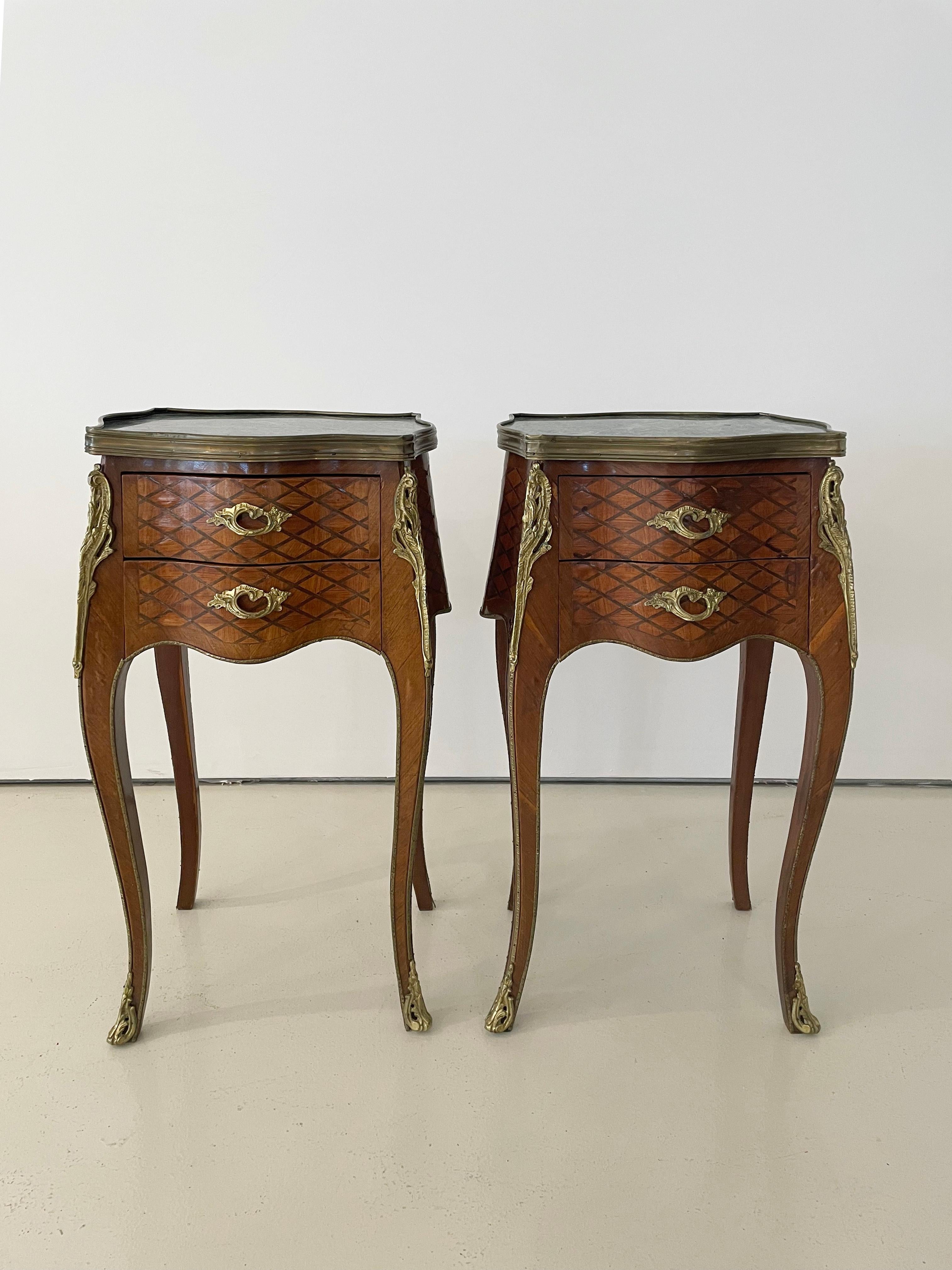 Tables d'appoint anciennes en bois massif sculpté de style Louis XV avec placage de parquet décoratif 

Quincaillerie d'angle, poignées et pieds en métal moulé, finition dorée.

Bordure en laiton extrêmement détaillée. Veuillez voir les photos.