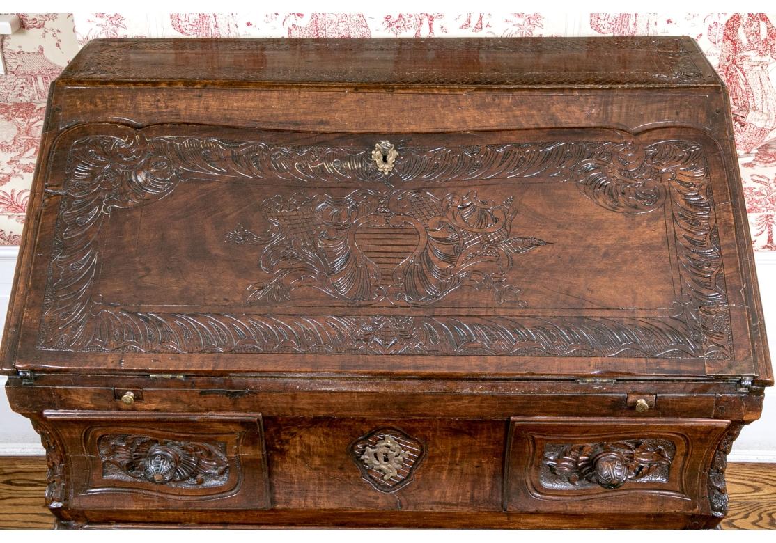 Scrivania in quercia in stile Luigi XV con intricati e dettagliatissimi intagli sul fronte, sul piano e sui lati. La porta smerlata, con chiave funzionante, si abbassa sostenuta da due cassetti. La segreteria si apre per rivelare quattro cassetti a