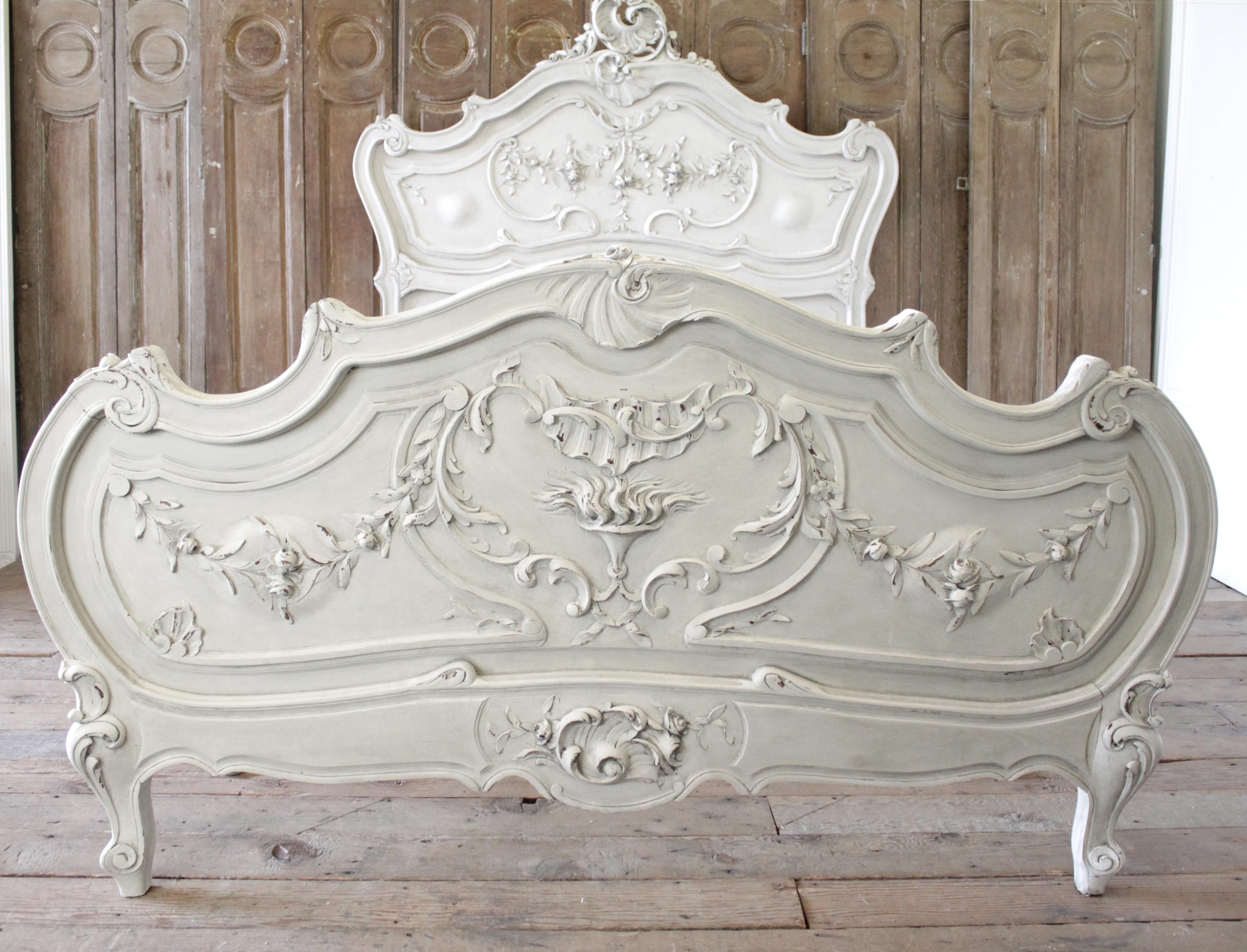 Antique Louis XV style painted French bed full size or Queen size
Beautifully painted in a soft oyster white finish, with subtle distressed edges, and finish with an antique patina. The headboard has a large carved cartouche, with heavy carved rose