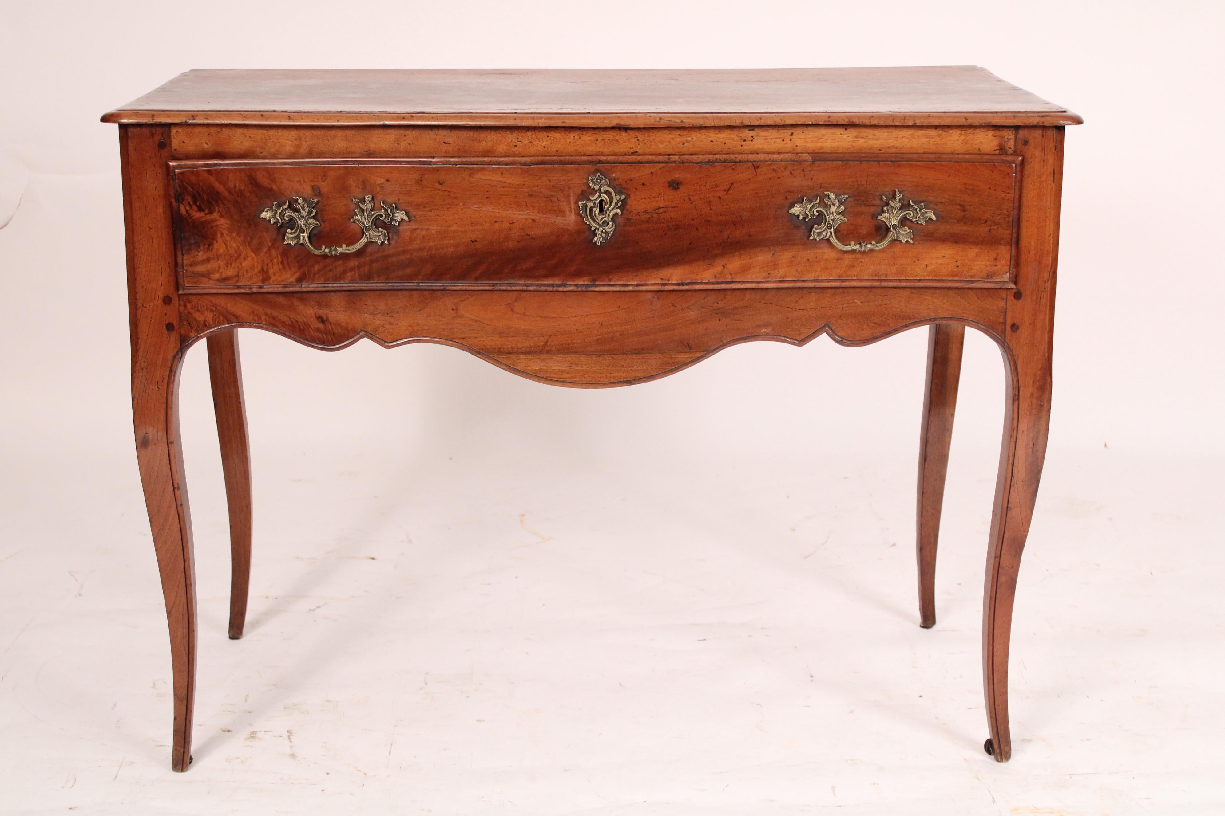 Antique Louis XV style provincial walnut console table, 19th century. The top with a serpentine shaped front molded front and side edges, a serpentine shaped drawer, a shaped apron, resting on cabriole legs. Hand dove tailed
drawer construction.