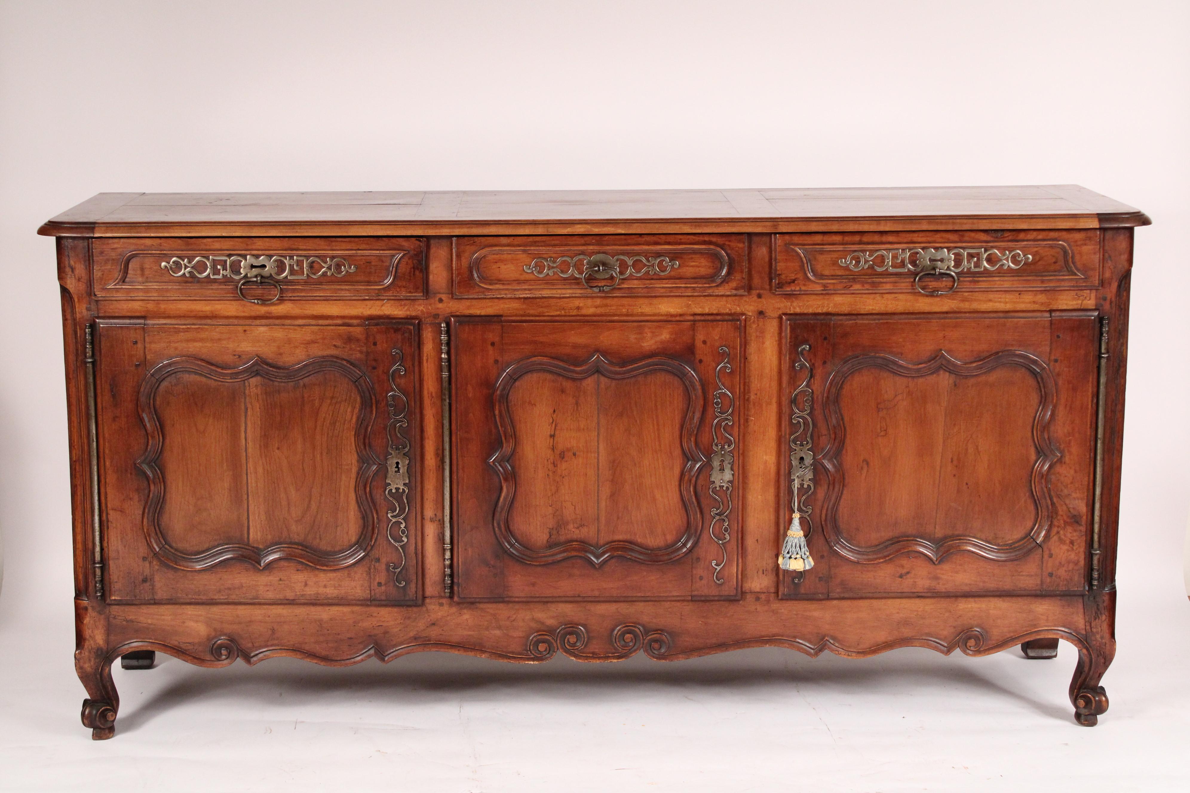 Antique Louis XV style provincial fruit wood enfilade, circa early 19th century. With a paneled rectangular top with rounded corners, 3 drawers with steel hardware, 3 doors each with cartouche moldings and inset fruit wood panels and steel
