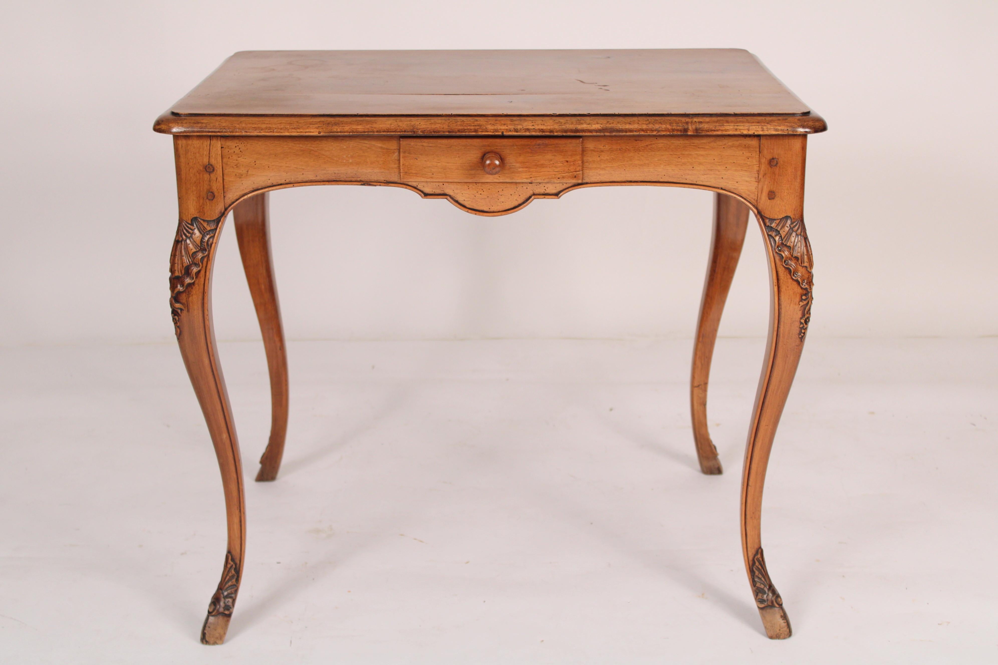 Antique Louis XV provincial walnut occasional / writing table, 19th century. With a rectangular overhanging top, serpentine shaped frieze apron with a drawer , resting on finely carved cabriole legs. Nice old color. Formerly sold by John Nelson