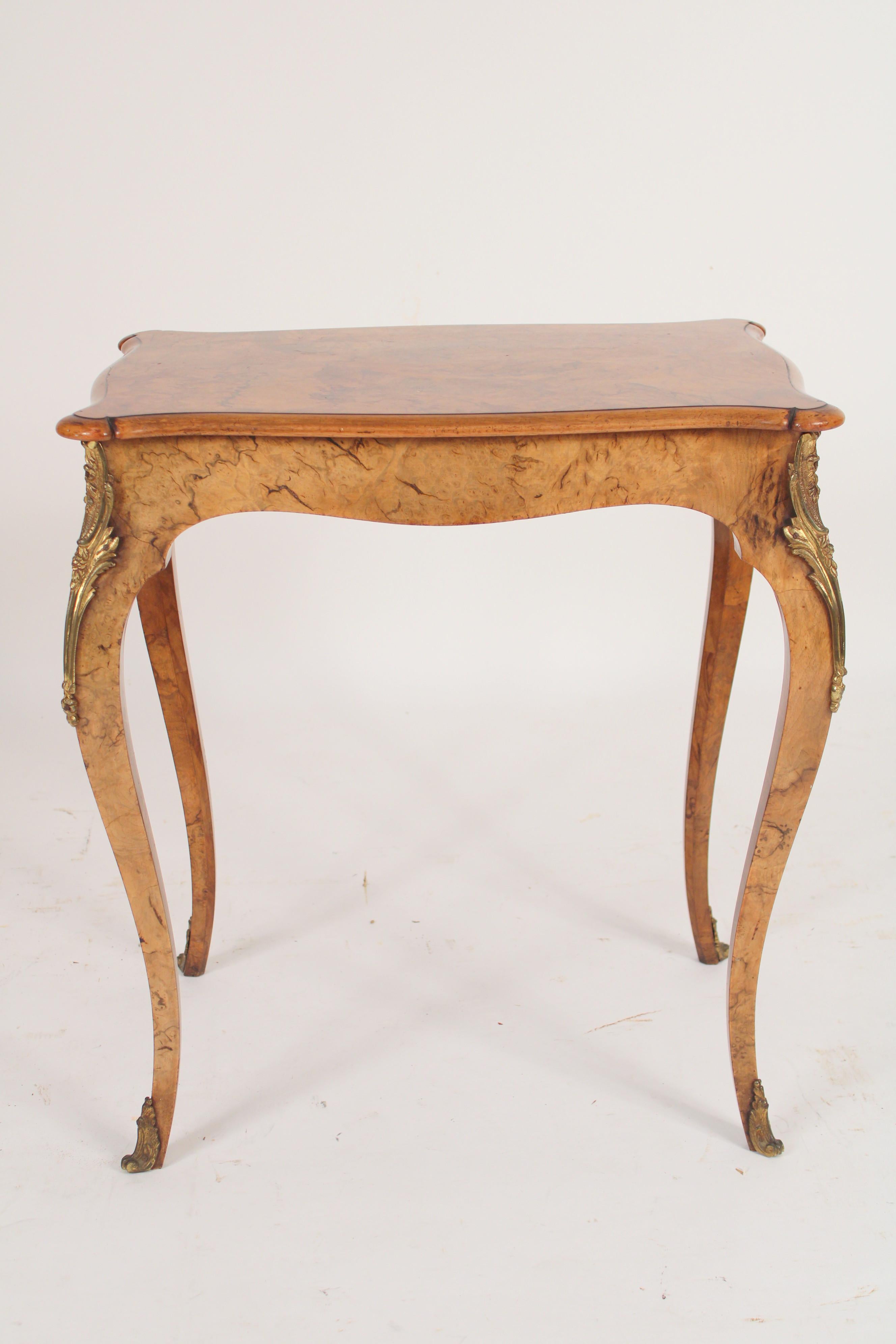 English Louis XV style burl walnut occasional table with chased brass mounts, circa 1910. Rectangular shaped top with serpentine shaped borders, serpentine shaped friezes, resting on burl walnut legs with chased brass mounts. Very nice quality burl