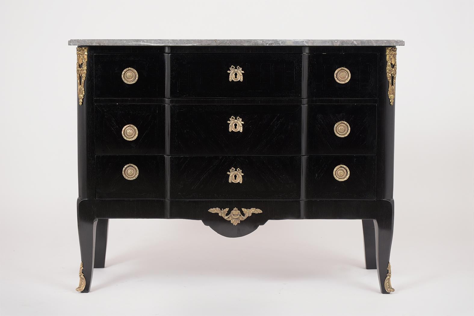 This antique French Louis XVI marble-top commode has been professionally restored, features its original dark grey color beveled marble-top, and newly ebonized lacquered finish. The commode comes with large brass accents on the corner/ front legs,