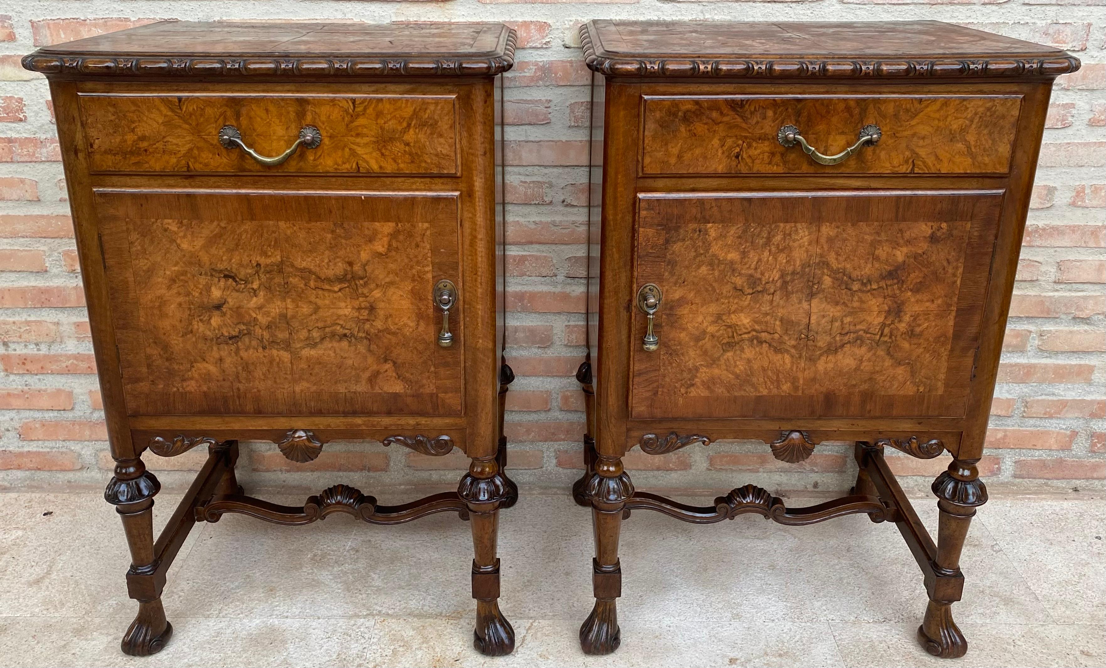 Pair of nightstands from the 1940s, made of walnut wood with walnut veneer.
They have an upper drawer and a door with an interior shelf.
The base rests on four claw legs joined by a very decorative central frame.
