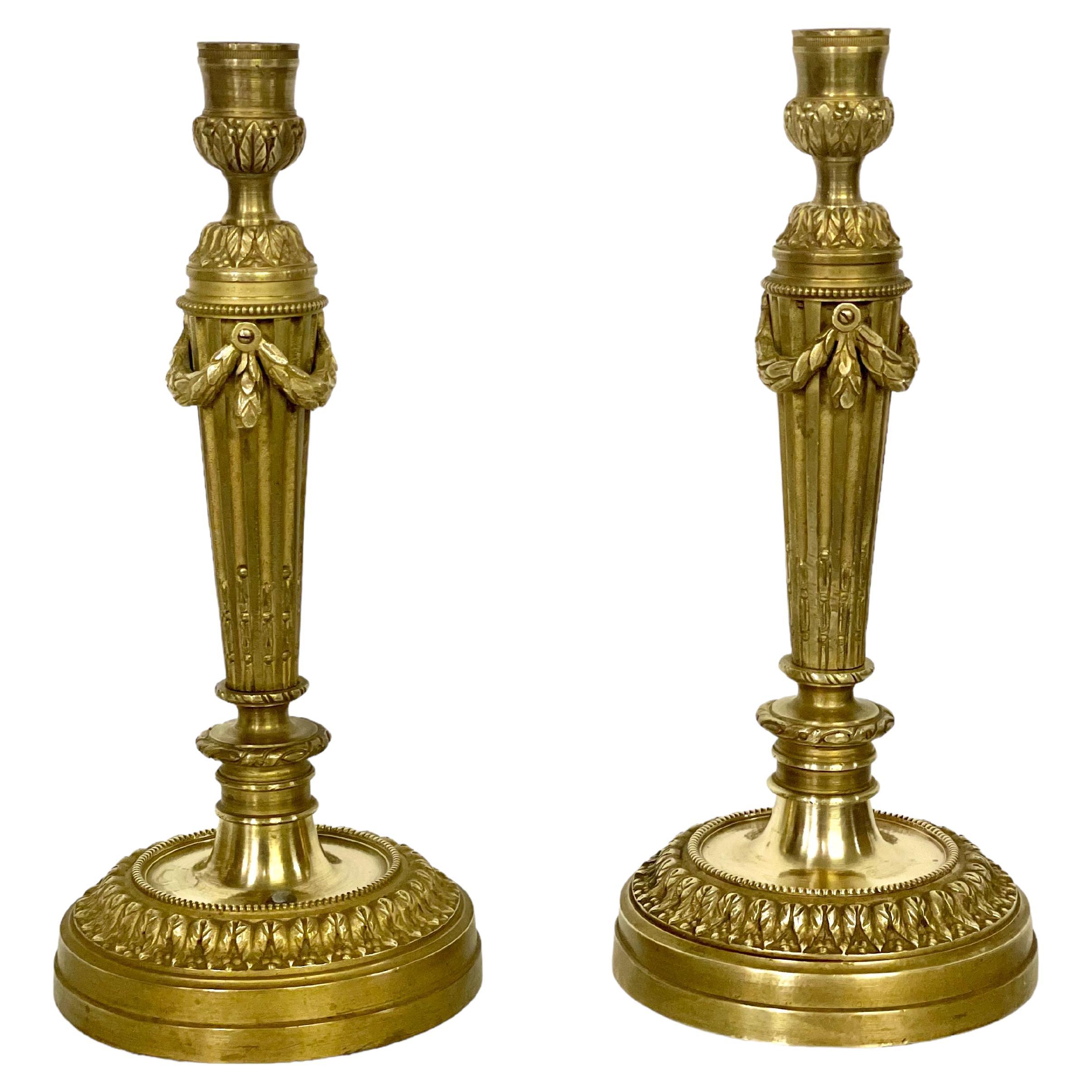 Antiguo par de elegantes candeleros Luis XVI de bronce dorado