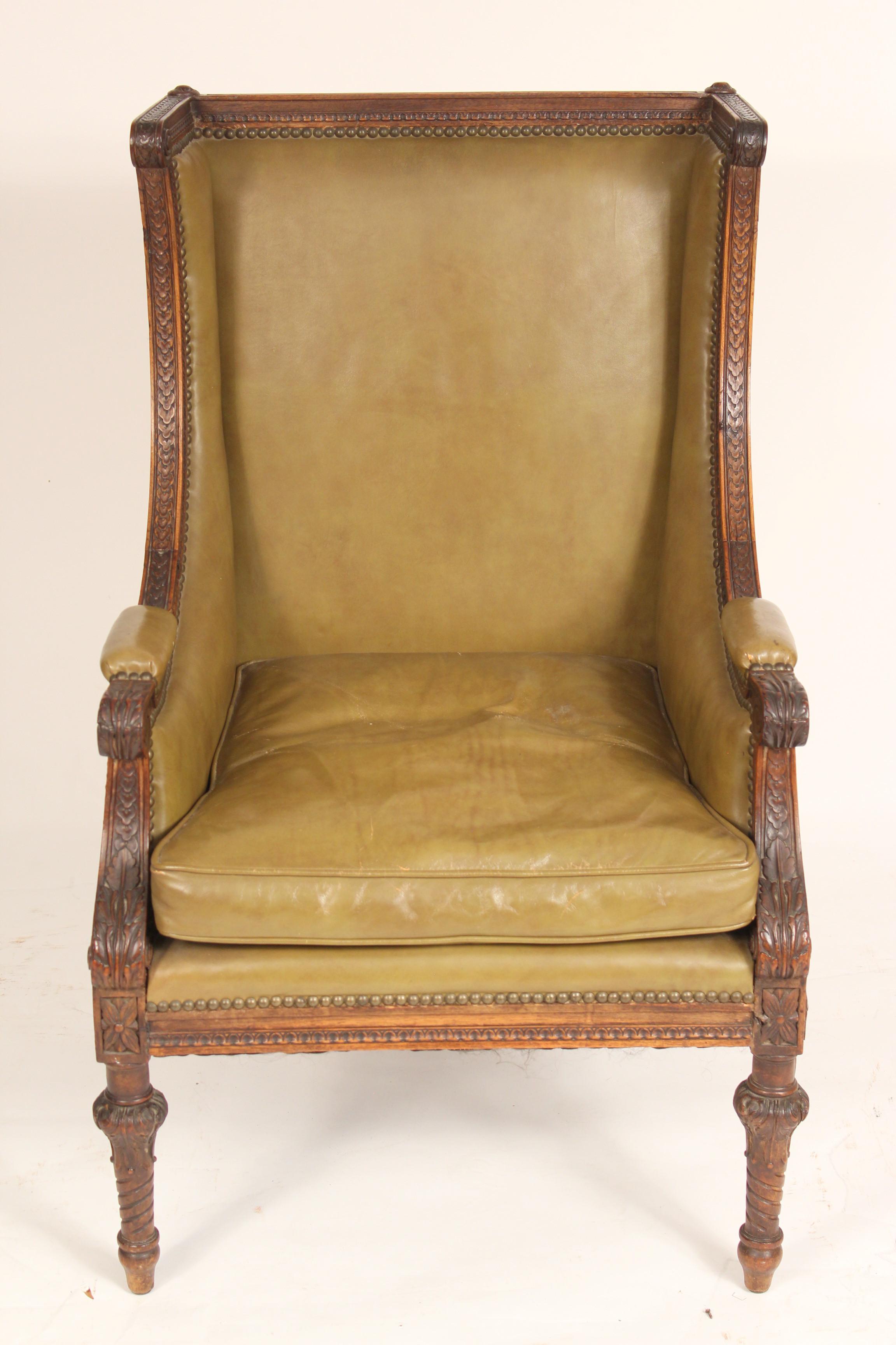 Antique Louis XVI style carved walnut bergere with leather upholstery, circa 1900. Nice quality hand carved walnut frame with leather upholstery.