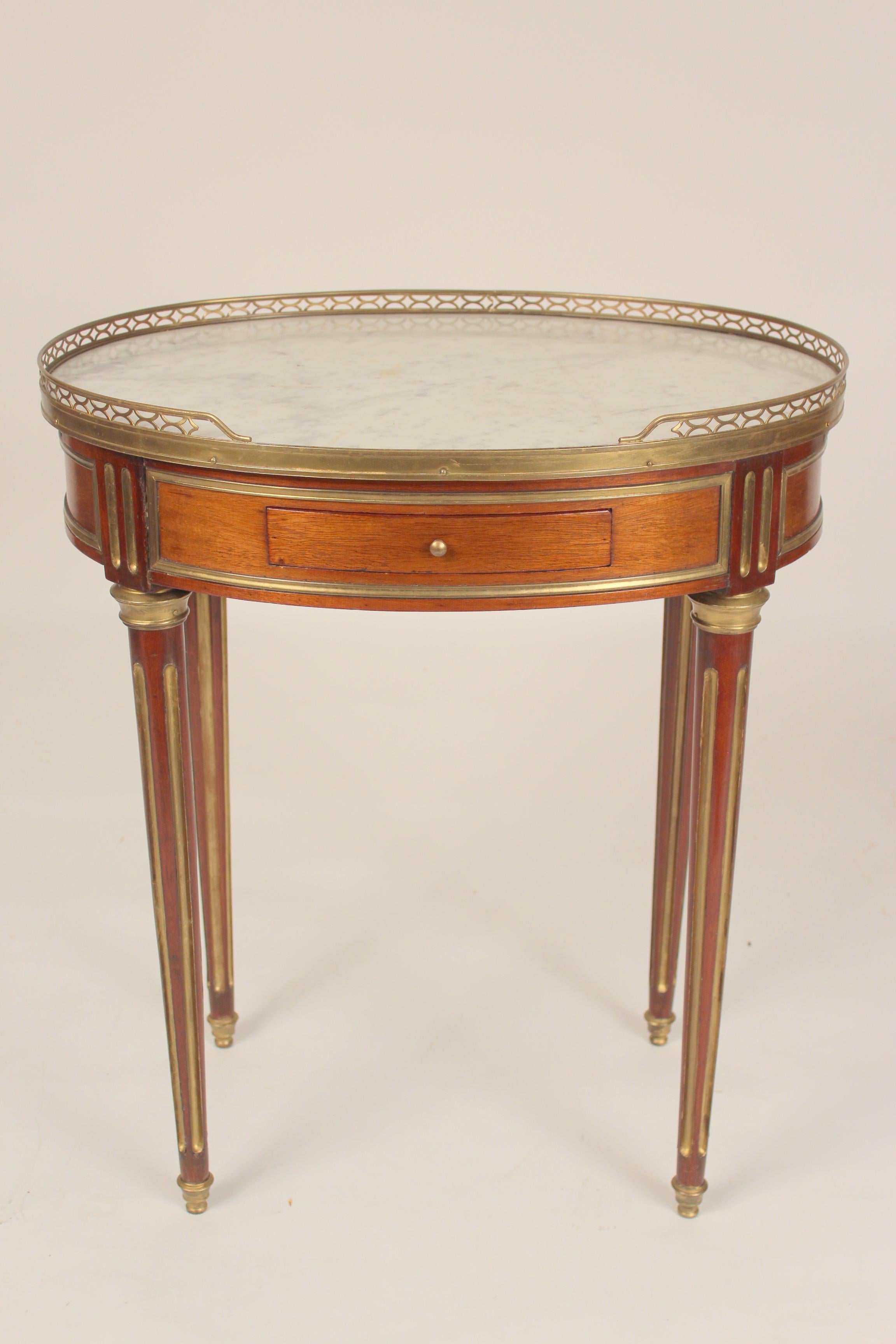 Antique Louis XVI style brass mounted mahogany occasional table with marble top and brass gallery, late 19th century.