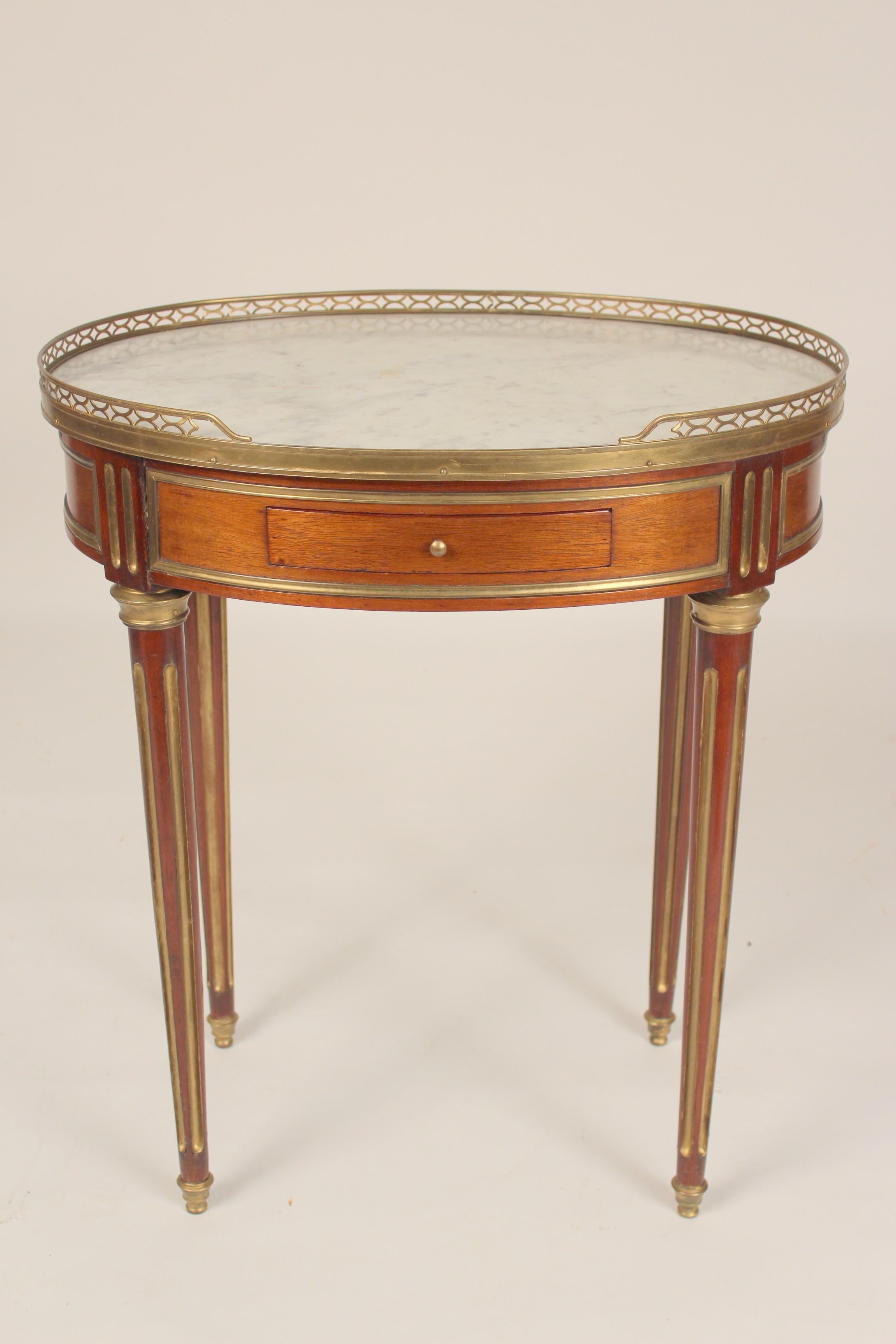 Antique Louis XVI style brass mounted mahogany occasional table with marble top and brass gallery, late 19th century.