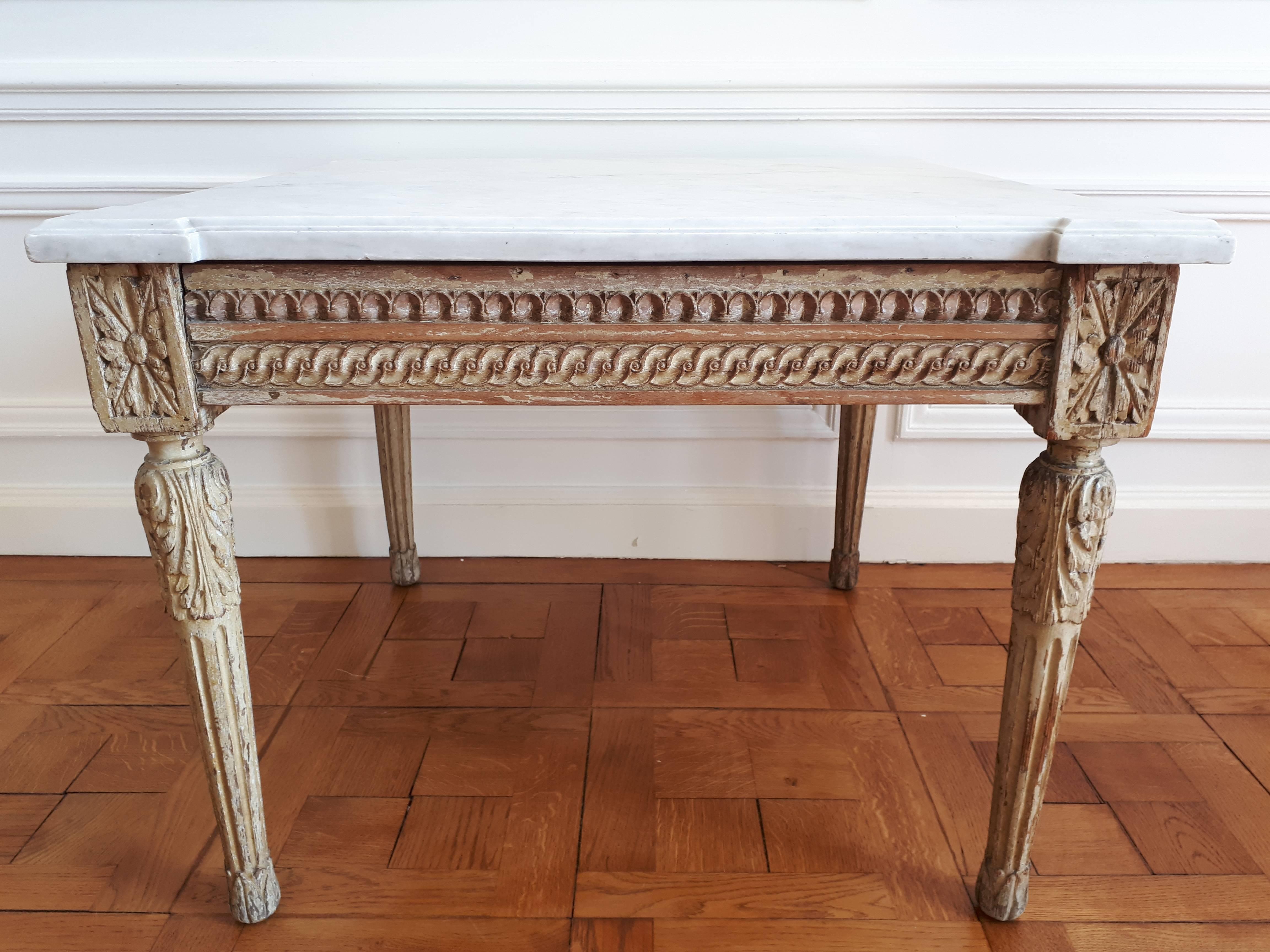Antiker Tisch im Louis-XVI-Stil aus dem 18. Jahrhundert, Marmorplatte mit bearbeiteten Kanten und ausgeprägten Ecken. 
Die Füße sind aus geschnitztem Holz und die Bemalung ist originell. Es handelt sich um ein Möbelstück, das ein echtes Know-how