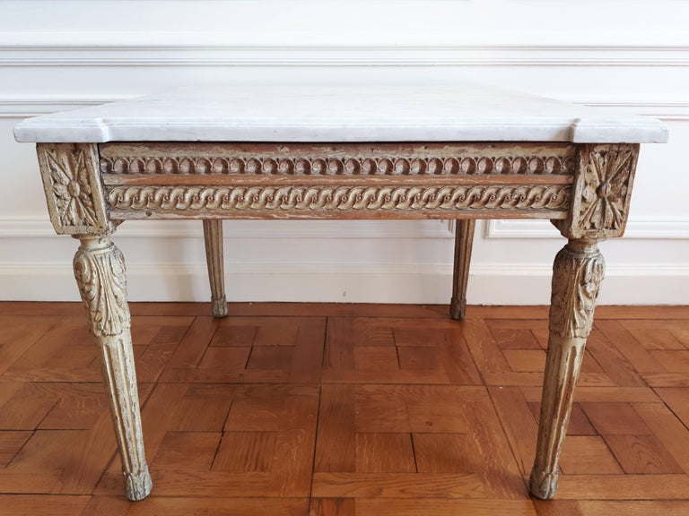 Antique Louis XVI style table from the 18th century, marble top with worked edges and pronounced corners. 
The feet are carved wood and the painting is original, it is as much a piece of furniture that represents a real know-how that a solid and