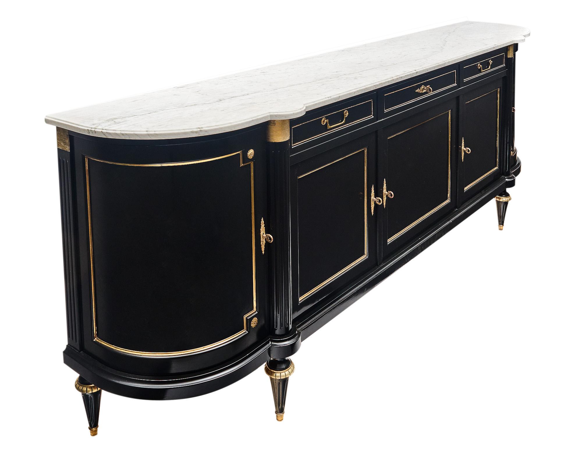 Buffet / enfilade from France made of a solid mahogany that has been finished in a museum-quality French polish for a lustrous effect. There are five doors that open to interior shelving and three dovetailed drawers. The buffet features gilt brass