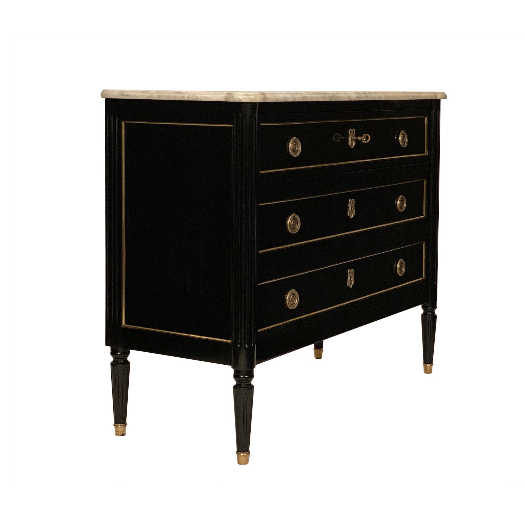 Antique Louis XVI style ebonized chest made of mahogany that has been finished with an ebonized French polish. The finely cast gilt bronze hardware and brass trims throughout add a classic elegance. Three dovetailed drawers provide storage solutions