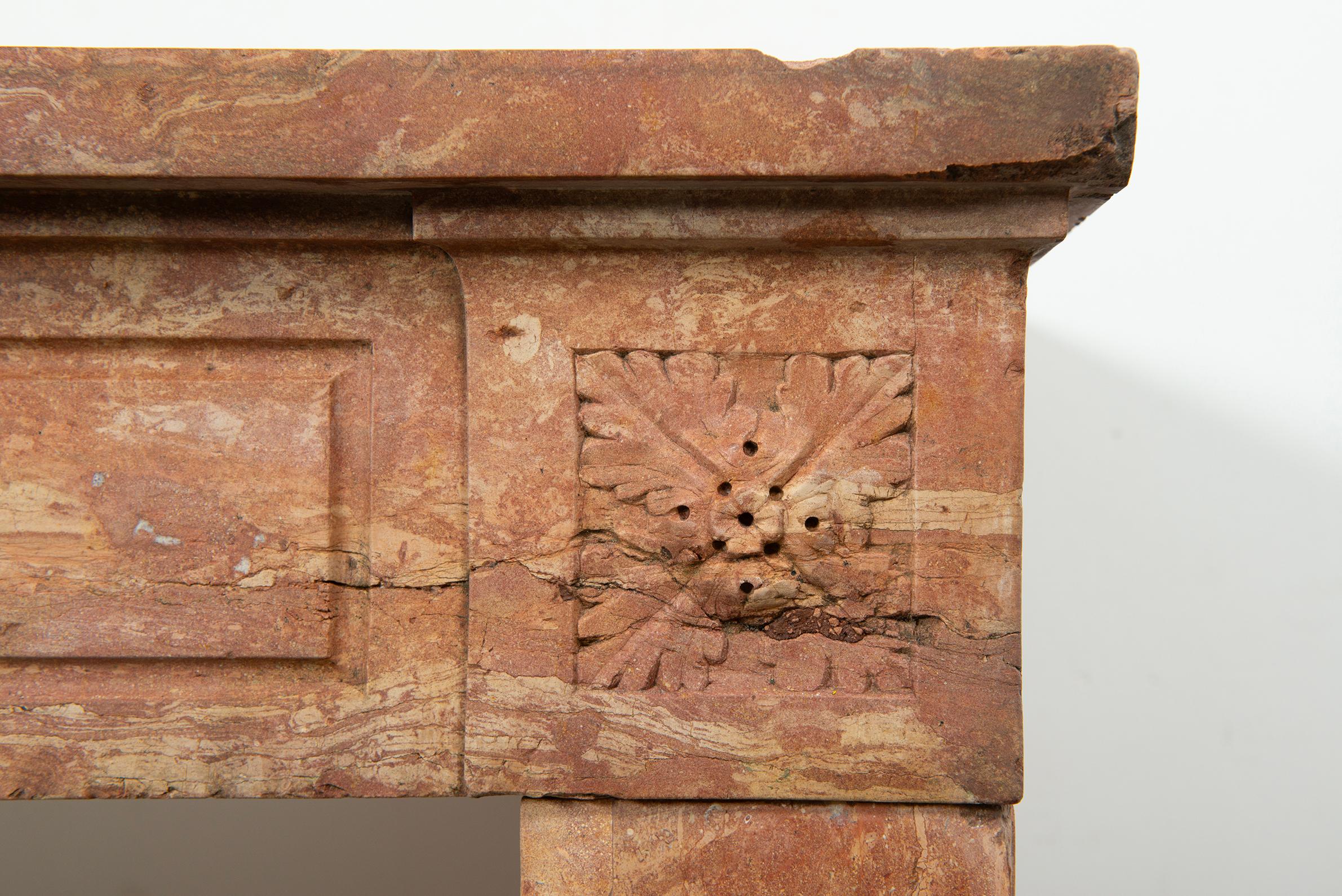 This exquisite Louis XVI-style fireplace, crafted from warm-hued limestone, captures the timeless elegance of French design. Originating from France, this piece features classical motifs, fluted columns, and intricate carvings that reflect the