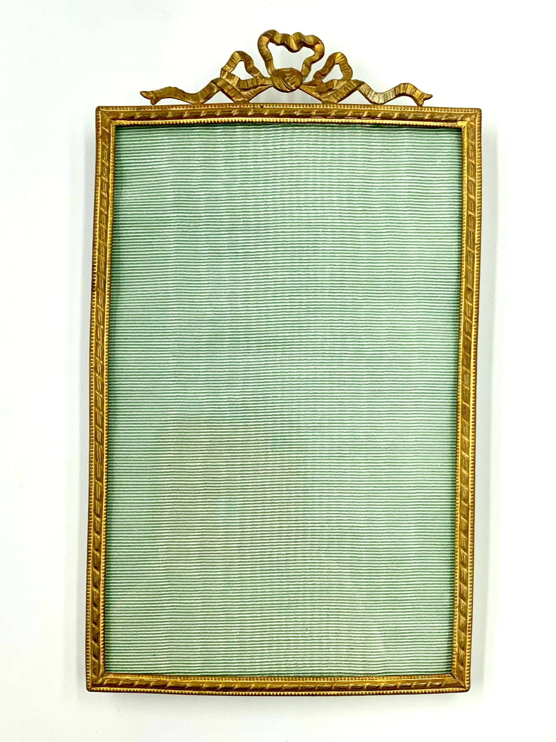 Antique French Louis XVI style gilt bronze picture frame
19th Century
Classic elaborate bow motif crest, stylized laurel leaf border with fine beaded details. Black velvet back with easel form support.
Excellent for adding a touch of elegance to a