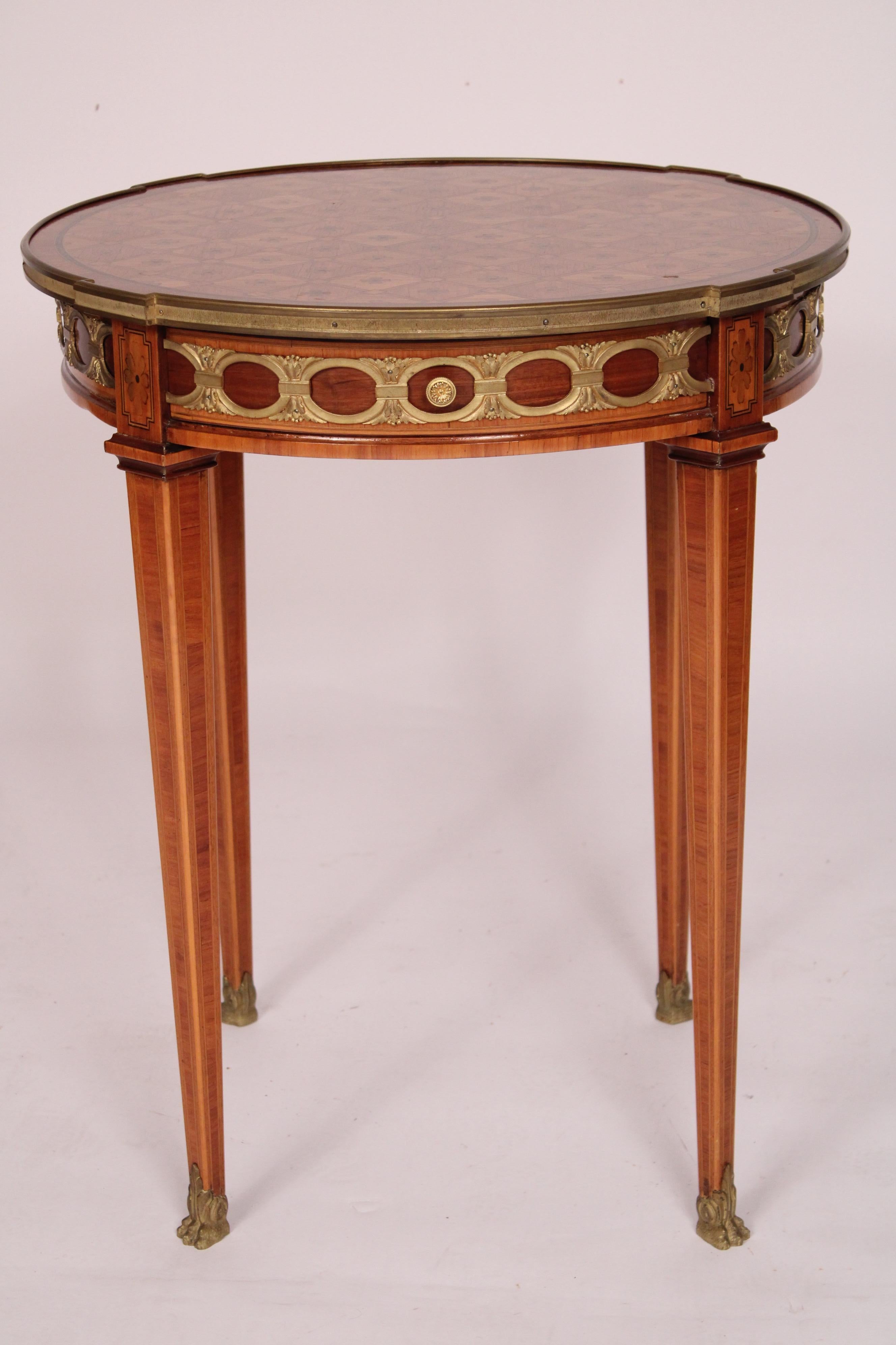 Antiker Gueridon im Stil Louis XVI, um 1920. Mit einer runden Platte mit Intarsien aus Mahagoni und Königsholz, einem Fries mit Beschlägen aus Mahagoni, Tulipwood und Ormolu, quadratischen, konischen Beinen aus Tulipwood und Mahagoni, die in