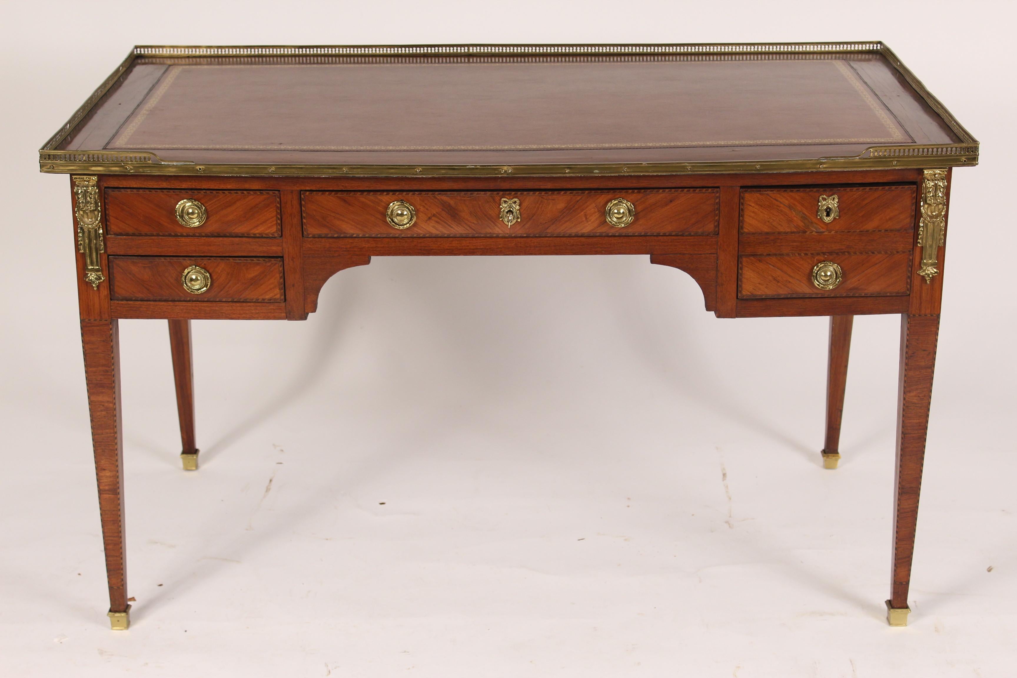 Antique Louis XVI style tulip wood desk with a tooled leather top and a brass gallery, late 19th century.