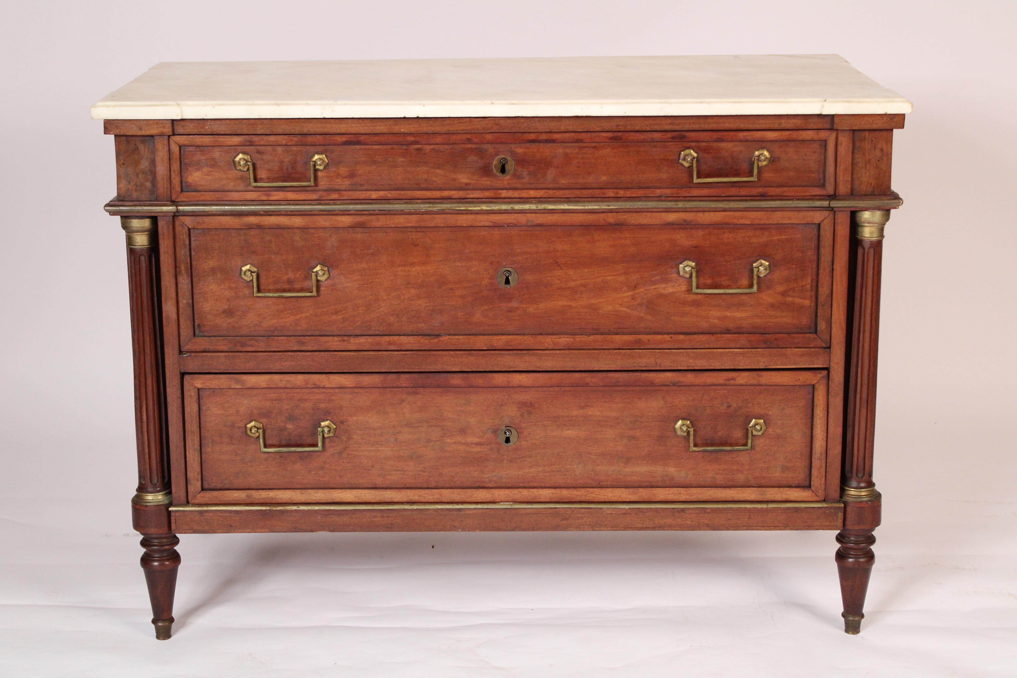 Antique Louis XVI style mahogany chest of drawers with marble top and brass moldings, 19th century. With a rectangular white marble top with molded front and side edges, 3 mahogany drawers with brass pulls, flanked by fluted mahogany columns with