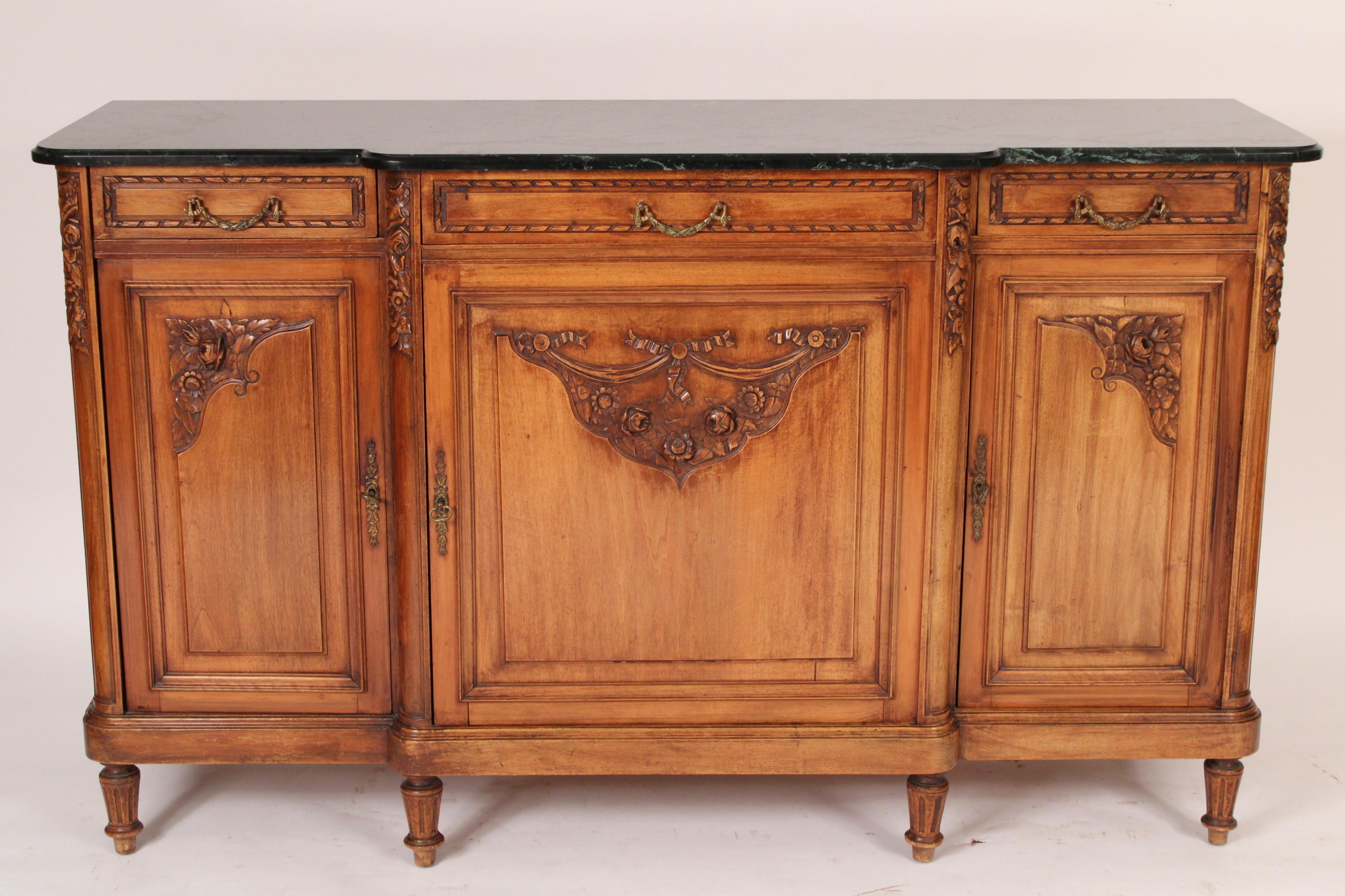 Louis XVI style walnut and beech wood marble top buffet, circa 1910. With a replaced dark green marble top over 3 drawers with bronze swag drawer pulls, three doors with foliate carvings, resting fluted tapered legs. Nice walnut color. Hand dove