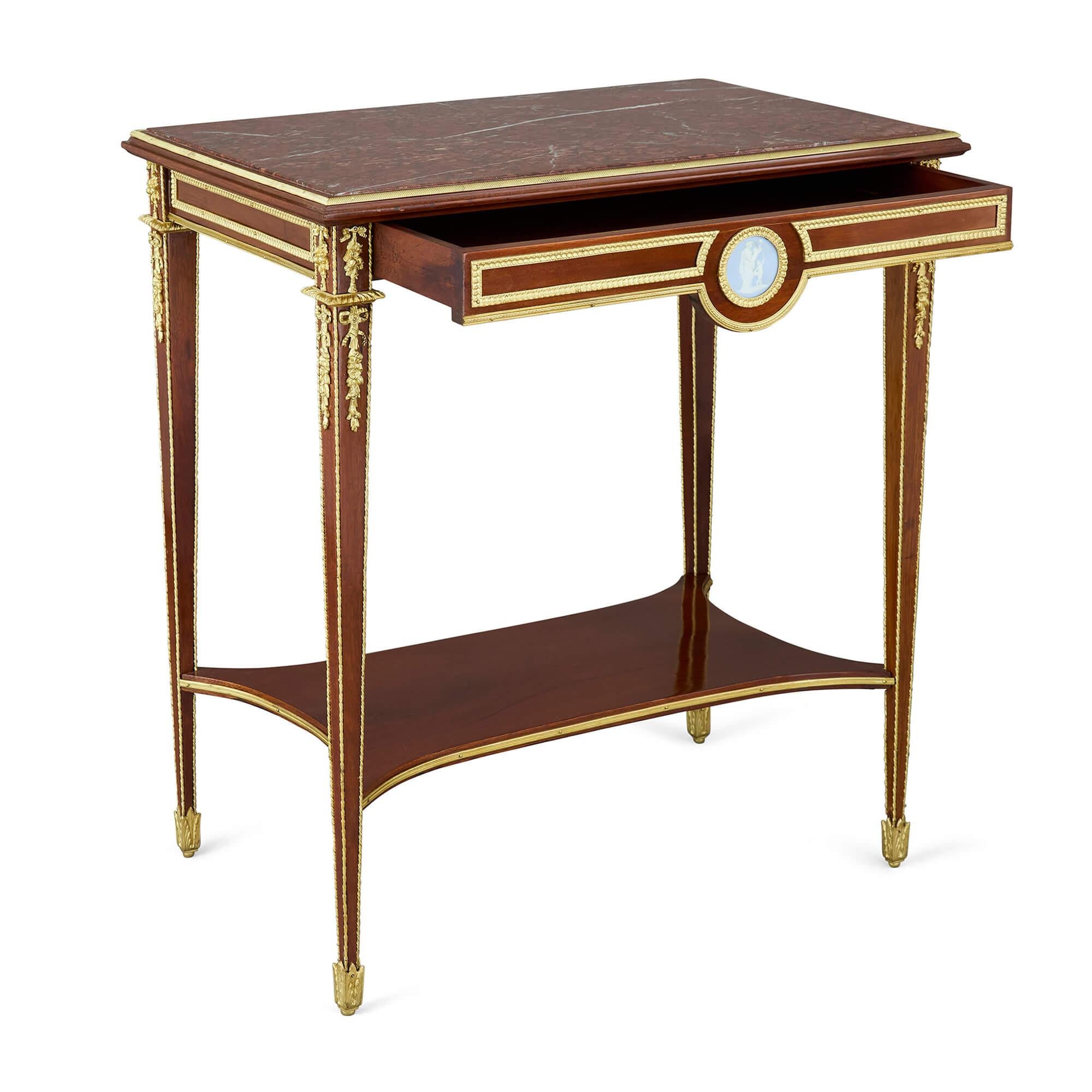 Antigua mesa auxiliar Luis XVI montada en ormolu y jaspe 
Francés, finales del siglo XIX 
Altura 76 cm, anchura 69 cm, profundidad 44 cm

Esta mesa auxiliar de finales del siglo XIX se inspira en la refinada estética Luis XVI, muy de moda a finales