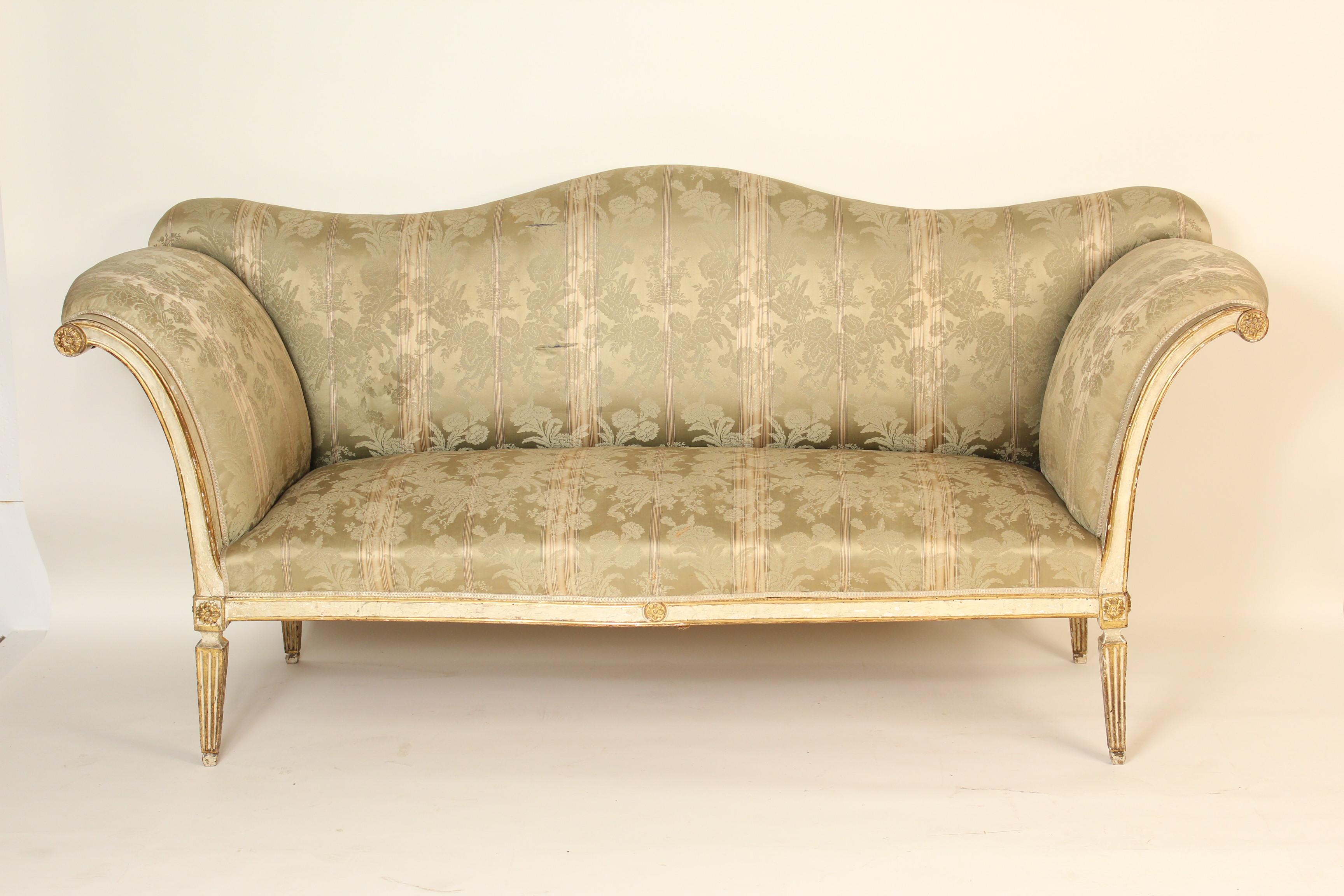 Antique continental Louis XVI style painted and parcel-gilt settee with a camel back and rolled arms, 19th century.