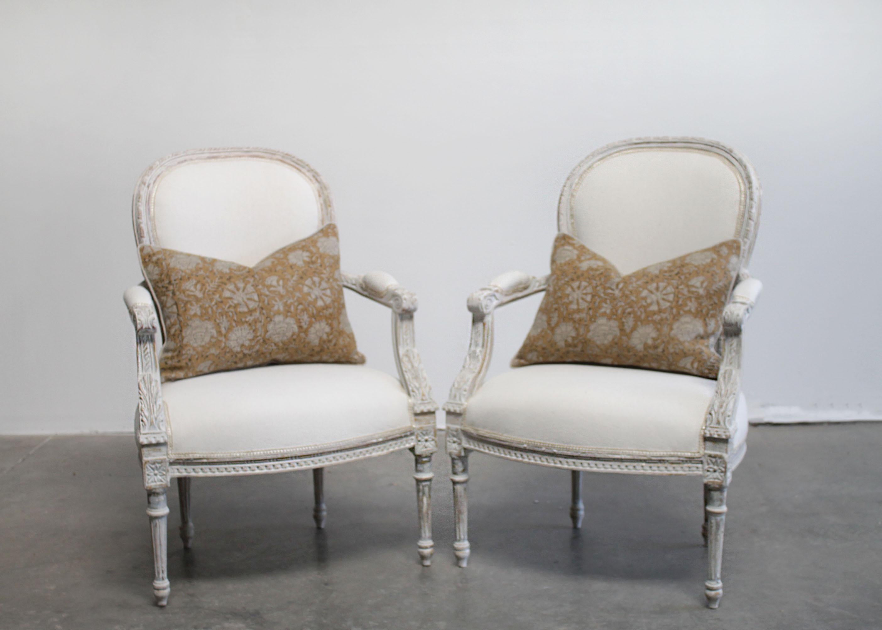 Antique Louis XVI style painted and upholstered carved open armchairs
Painted in a pretty Gustavian gray finish with subtle distressed edges, and wood peeking through the paint.
Classic fluted legs, with medallion carvings atop the leg.
Size: 25