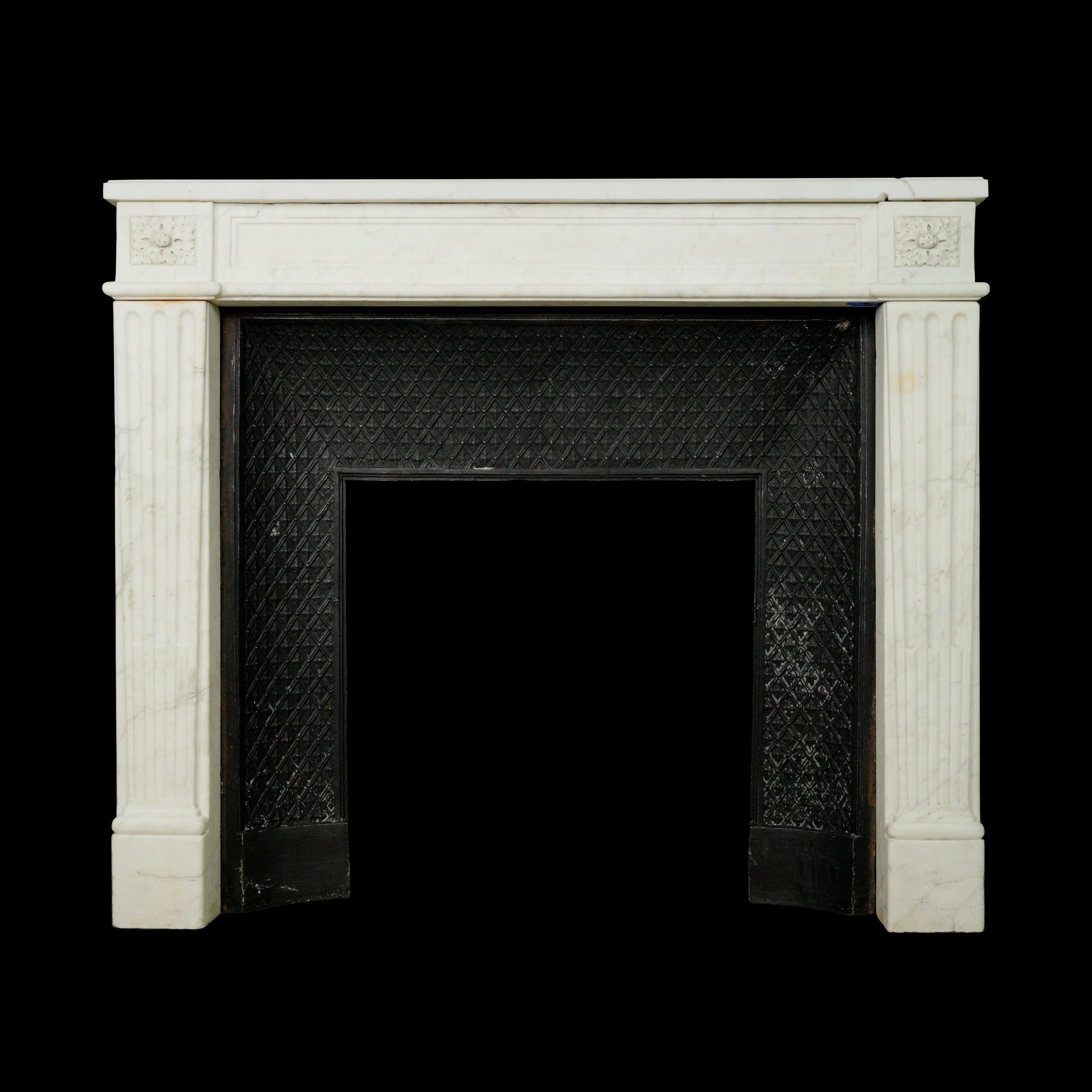 Cette pièce provient d'une succession estimée située à Greenwich, Connecticut. La cheminée en marbre blanc, de style Louis XVI, est dotée d'un rétrécissement en fonte, ce qui contribue à son aspect classique et raffiné. Toutefois, il a subi une