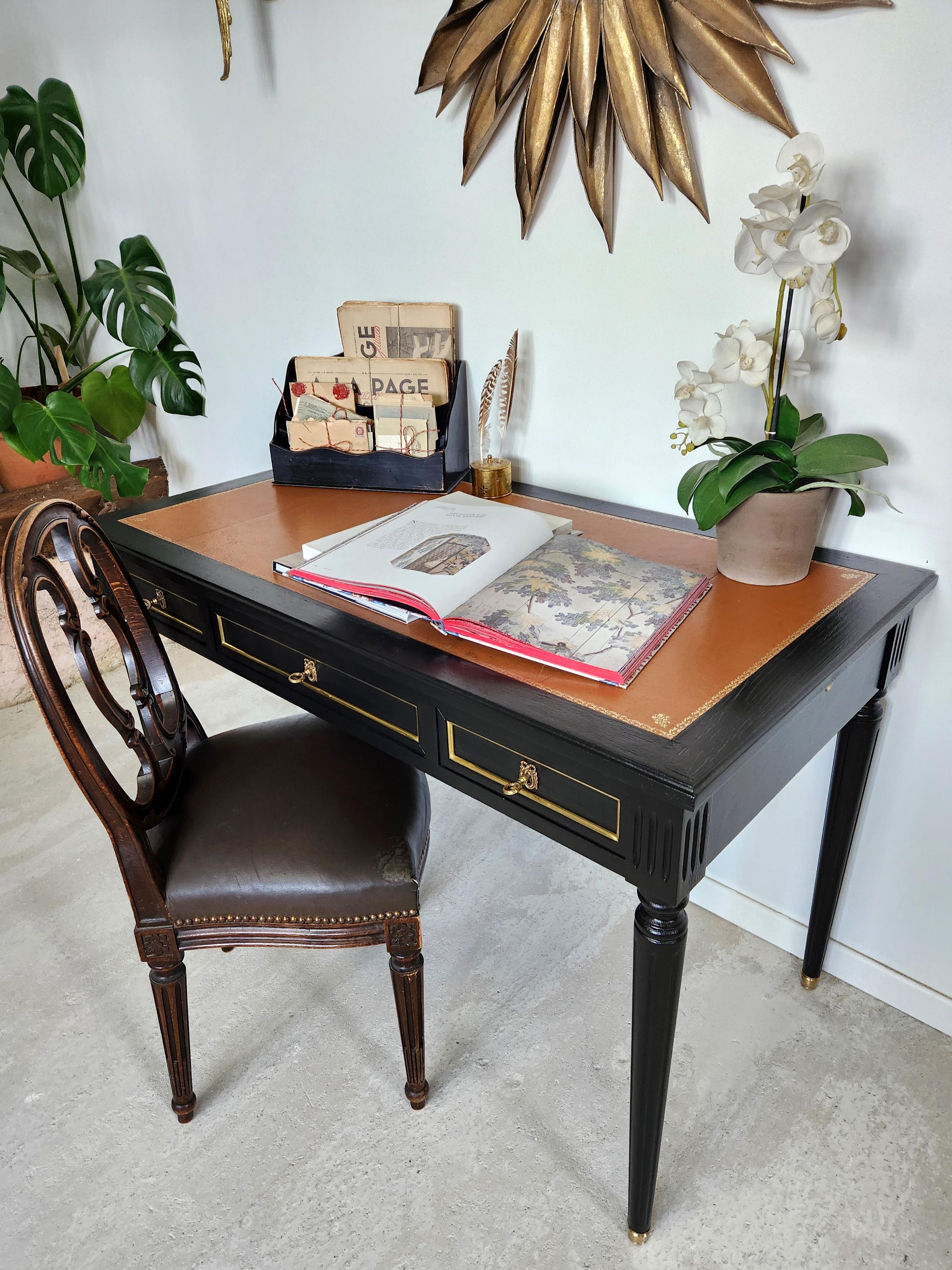 Antica scrivania in stile Luigi XVI con piano in pelle cognac e fregio in rilievo dorato, gambe scanalate rifinite con zoccoli in bronzo dorato.
Tre cassetti a coda di rondine con dettagli in ottone. 
Le serrature funzionano perfettamente e sono