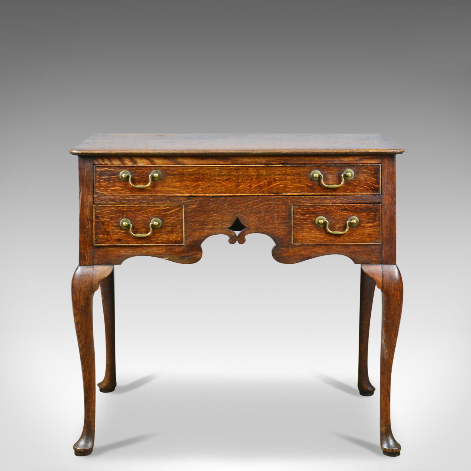 This is an antique lowboy, an English, late Georgian, oak table dating to the late 18th century, circa 1780.

Attractive golden hues to the wax polished oak
Good, consistent colour and grain interest throughout
Displaying wisps of medullary