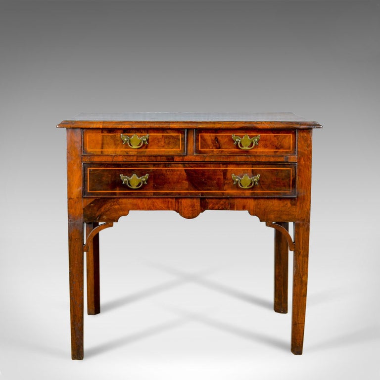 This is an antique lowboy, an English, Georgian, walnut side table dating to the turn of the 19th century, circa 1800.

Grain interest and desirable color to the attractive walnut
Of good proportion with an aged patina to the lustrous wax