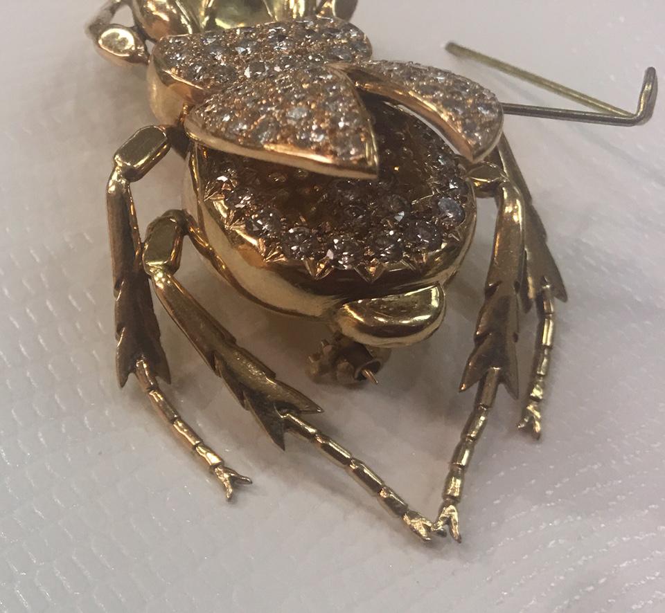 Stylish and finely detailed Unique Antique Scarab beetle set with Diamonds and Emerald eyes. Hand crafted in 18 Karat Yellow Gold; 88 Diamonds are set throughout the piece, along the back portion and under the articulated wings, approx. 1.75 total