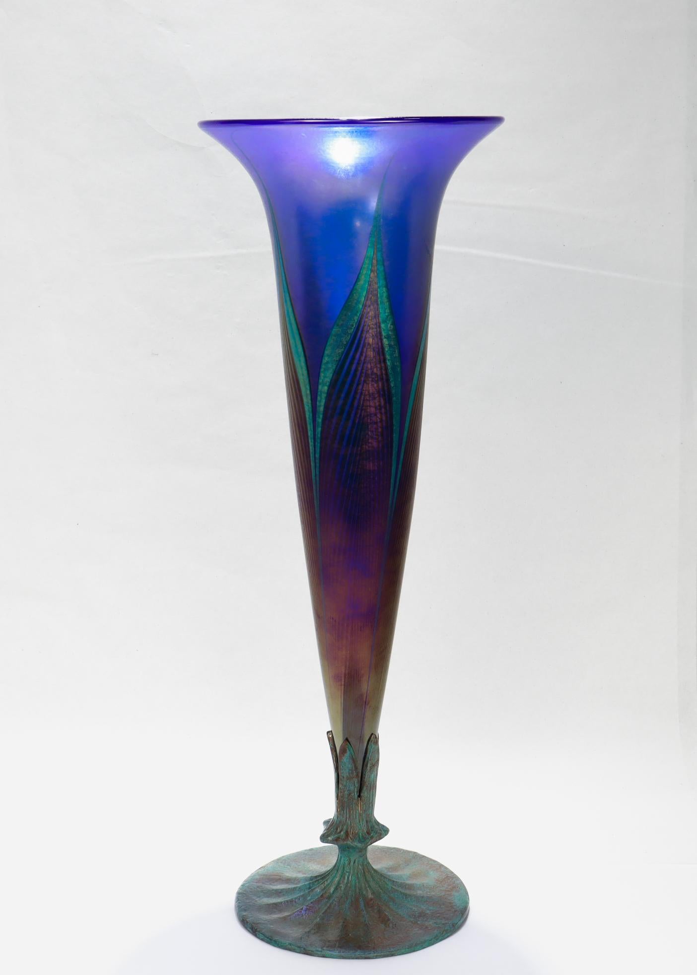 Eine schöne antike Vase aus Kunstglas.

Von Lundberg Studios.

Bestehend aus einer trompetenförmigen Vase aus irisierendem Favrilglas mit einem gezogenen Pfauenfedermuster, montiert auf einer Kupferfassung mit Trompetenfuß.

Die Lundberg Studios