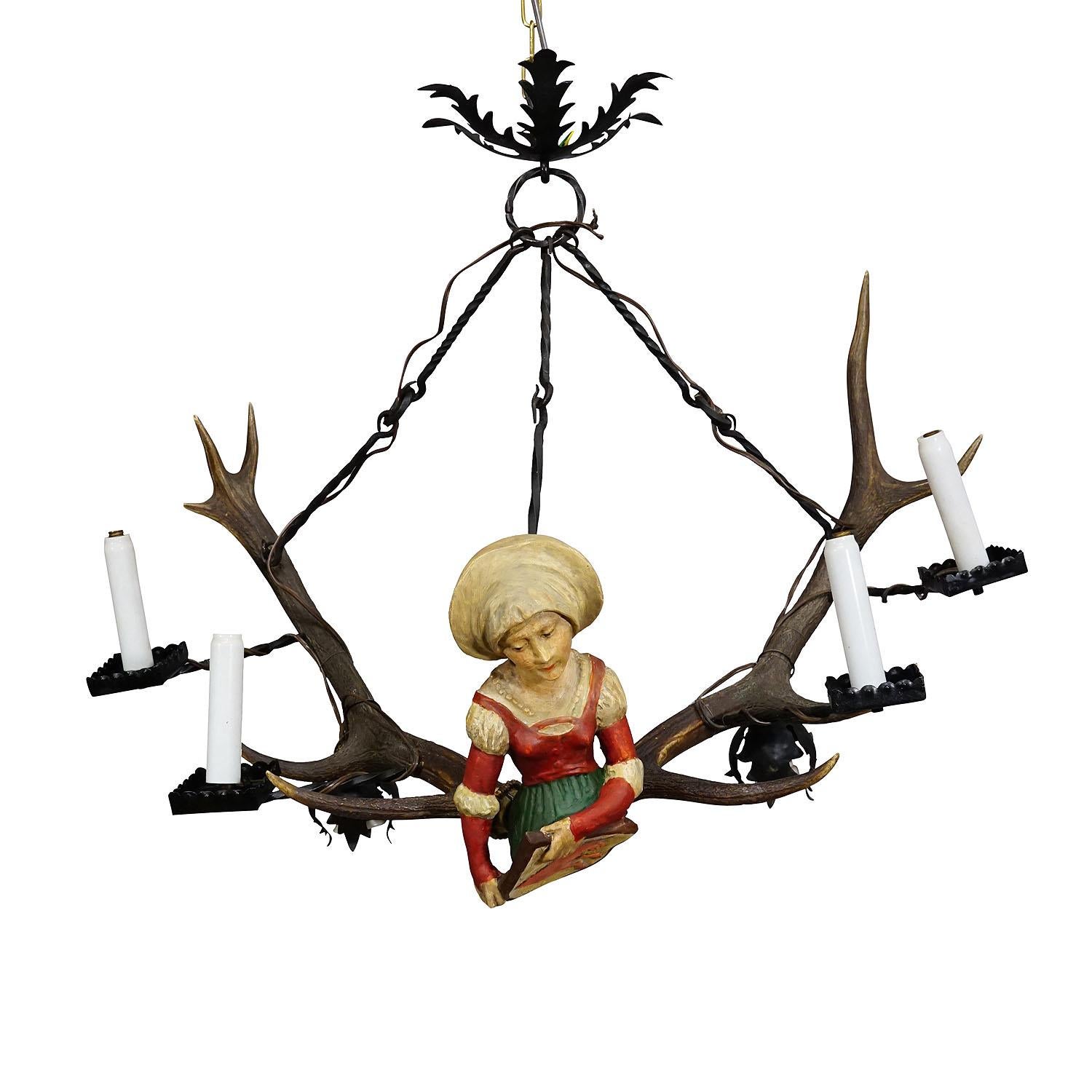 Antique Lusterweibchen of a Medieval Noble Lady ca. 1880s

A great antique chandelier featuring a medieval noble lady holding a heraldic blazon. The sculpture is made of handcarved and painted wood and mounted on a large pair of deer antlers. It