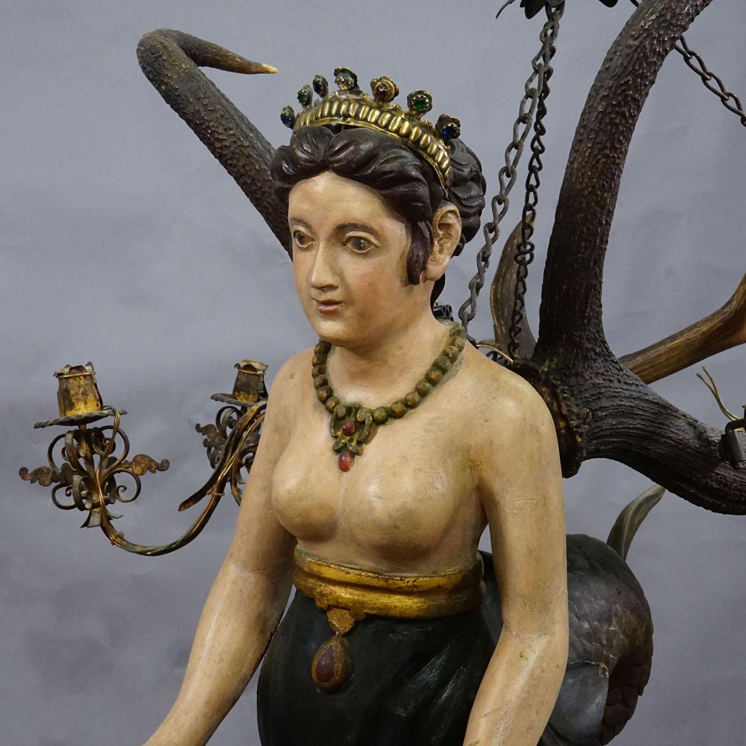 Antico Lusterweibchen di una sirena del 1900 ca.

Un raro lampadario antico con una figura di sirena dall'espressione nobile e dai capelli fluenti. La scultura in legno è finemente intagliata e dipinta a mano e raffigura una sirena adornata con