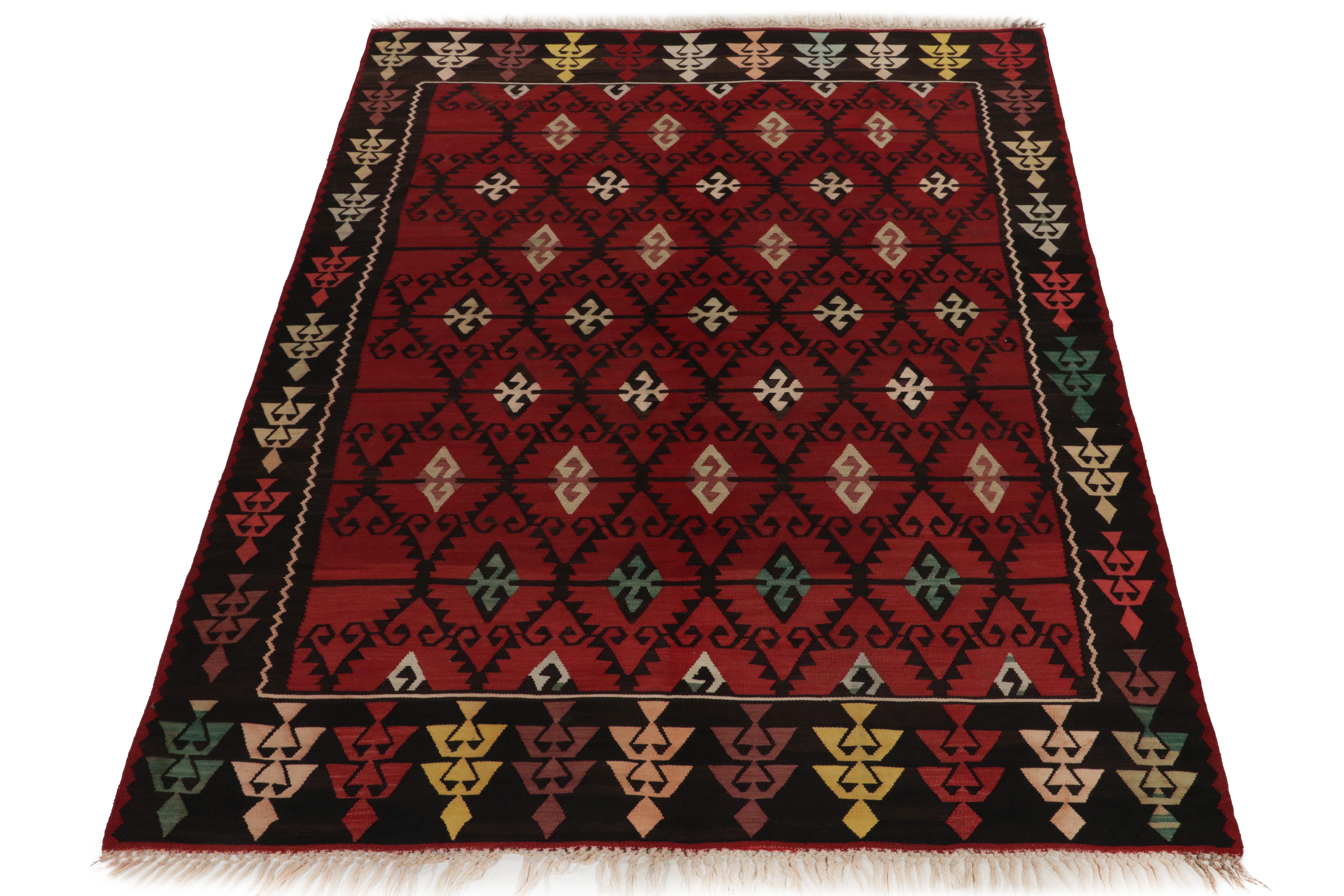 Handwoven in wool, a 7 x 10 antique kilim rug from our flatweave selections. Originating from Turkey circa 1910-1920, this rare Macedonian flat weave style carries nomadic inspiration with a striking diamond pattern in rich red, black accenting to