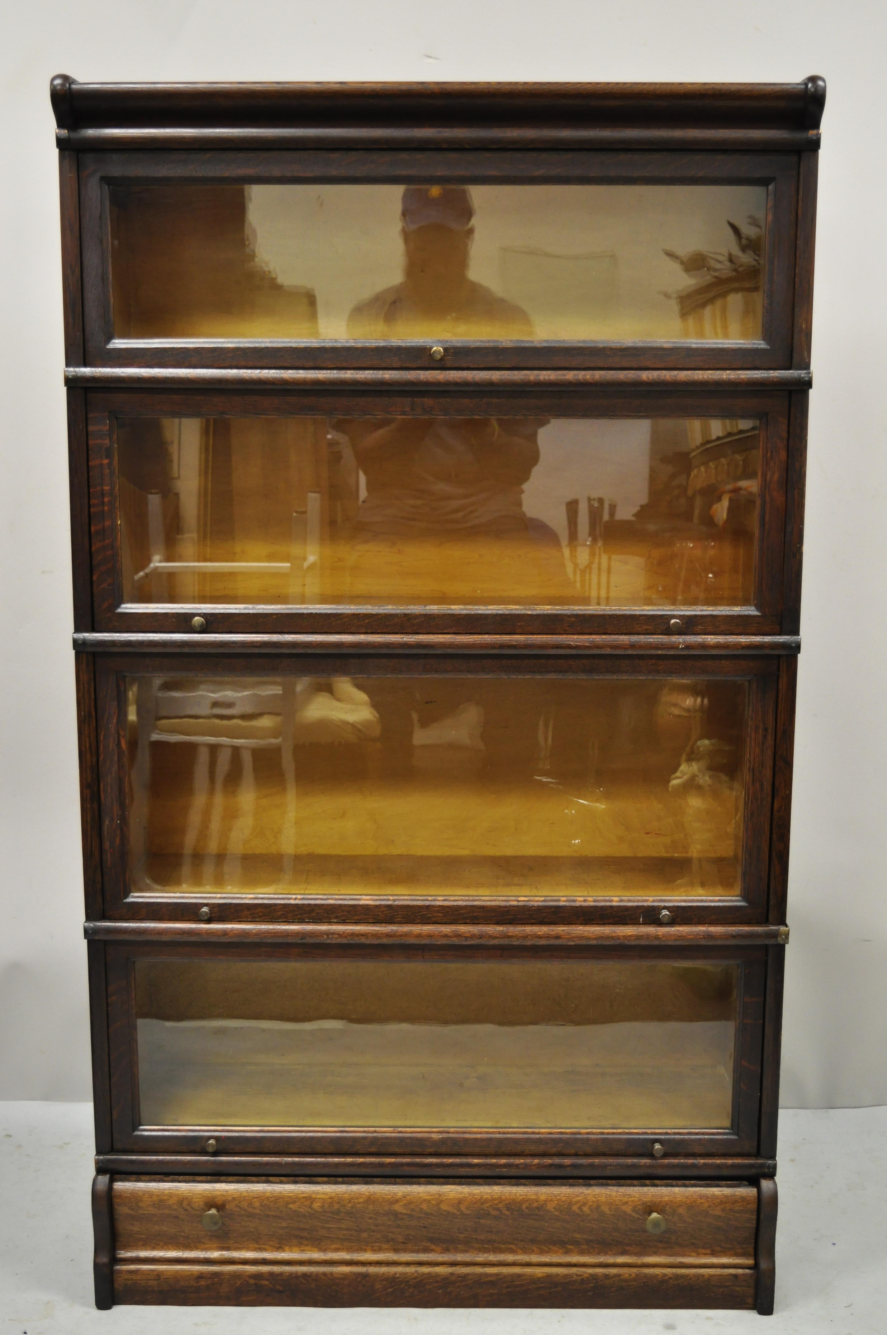 Antique Macey tiger oak barrister stacking lawyers bookcase 4 sections with drawer. Item features dovetailed drawer to base section, (4) sliding glass stacking bookcase sectionals, metal side bands, beautiful wood grain, original label, very nice