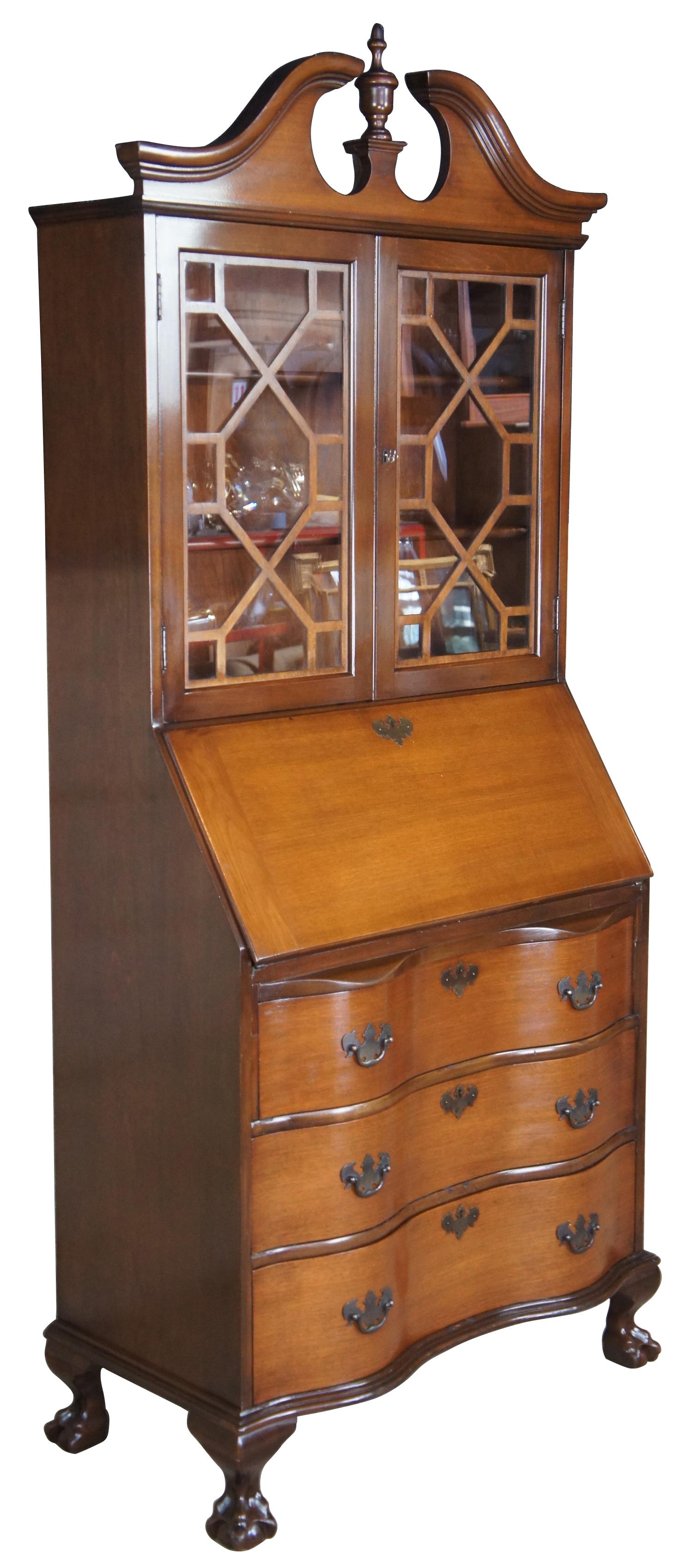 A gorgeous serpentine front one piece secretary desk by Maddox Tables of Jamestown NY. Made from American walnut. Interior opens to four drawers and multiple divided and hidden compartments. Upper bookcase portion shows an open pediment with turned
