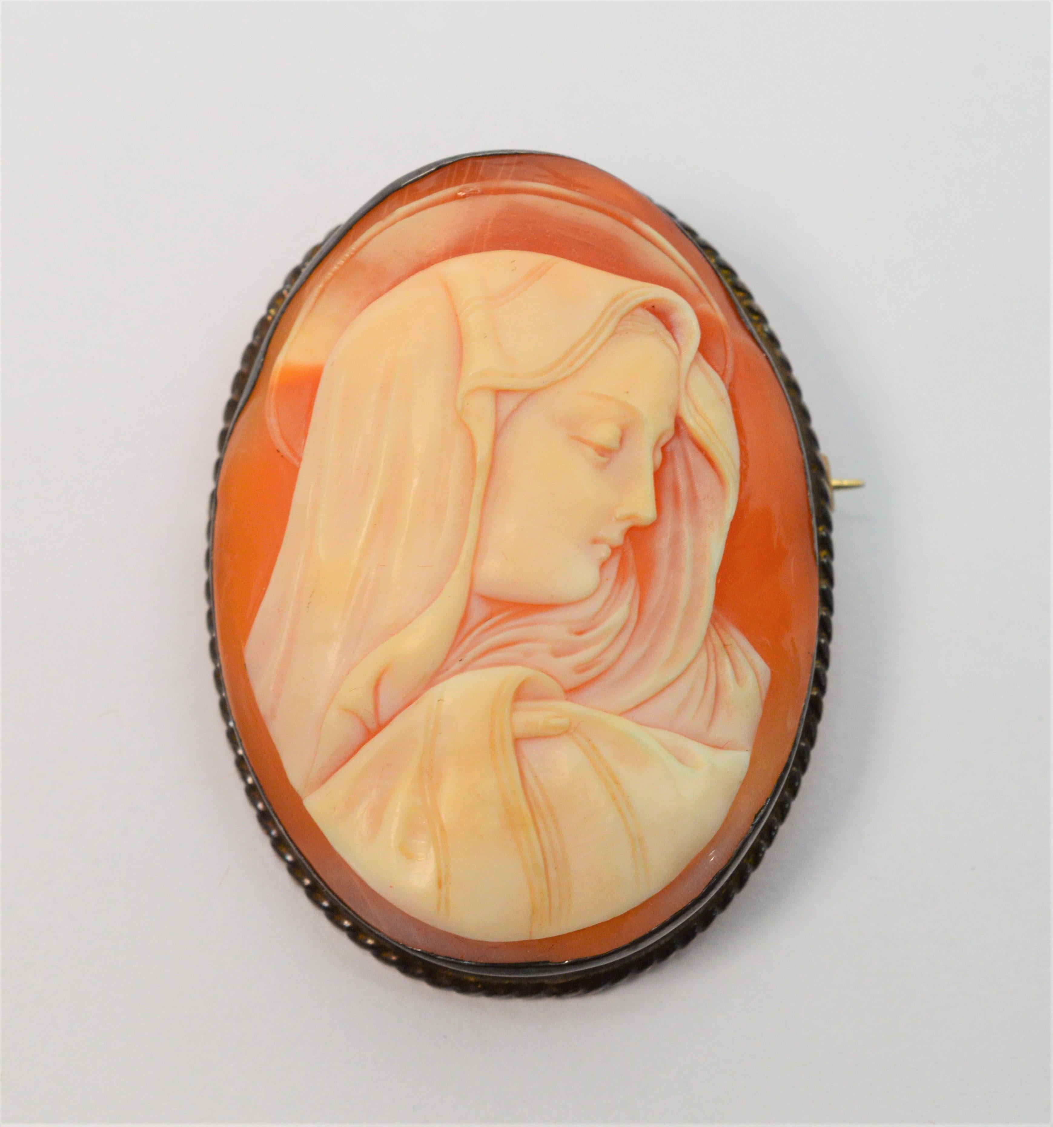 An inspiring portrait of the Blessed Mother is hand carved to create this lovely oval antique shell cameo brooch. Artisan framed in toned sterling silver, the Madonna's image has extraordinary fine life-like detail. This endearing piece can be